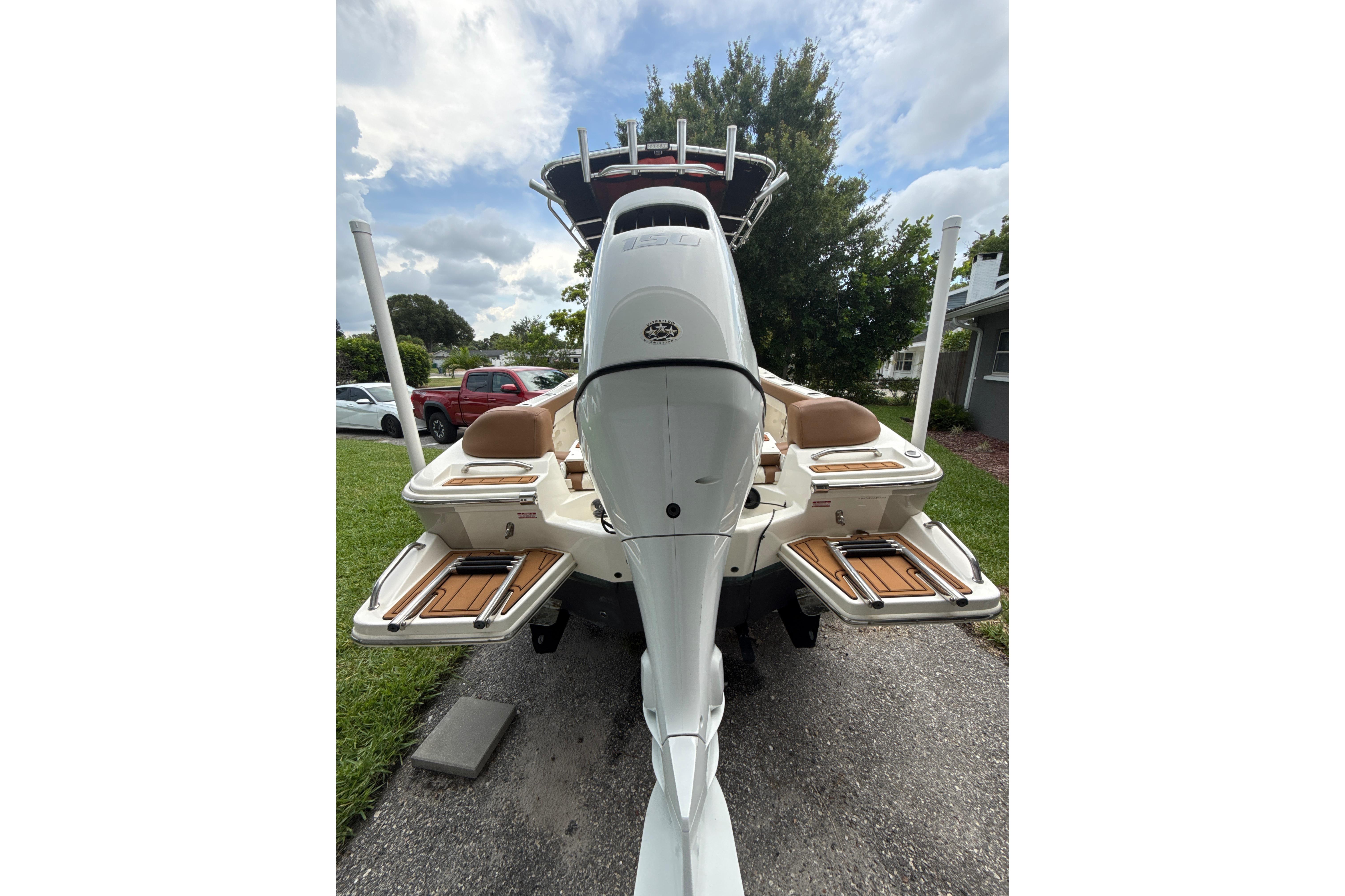 2023 Pioneer 202 Islander boat, rear view with outboard motor and seating, parked outdoors.