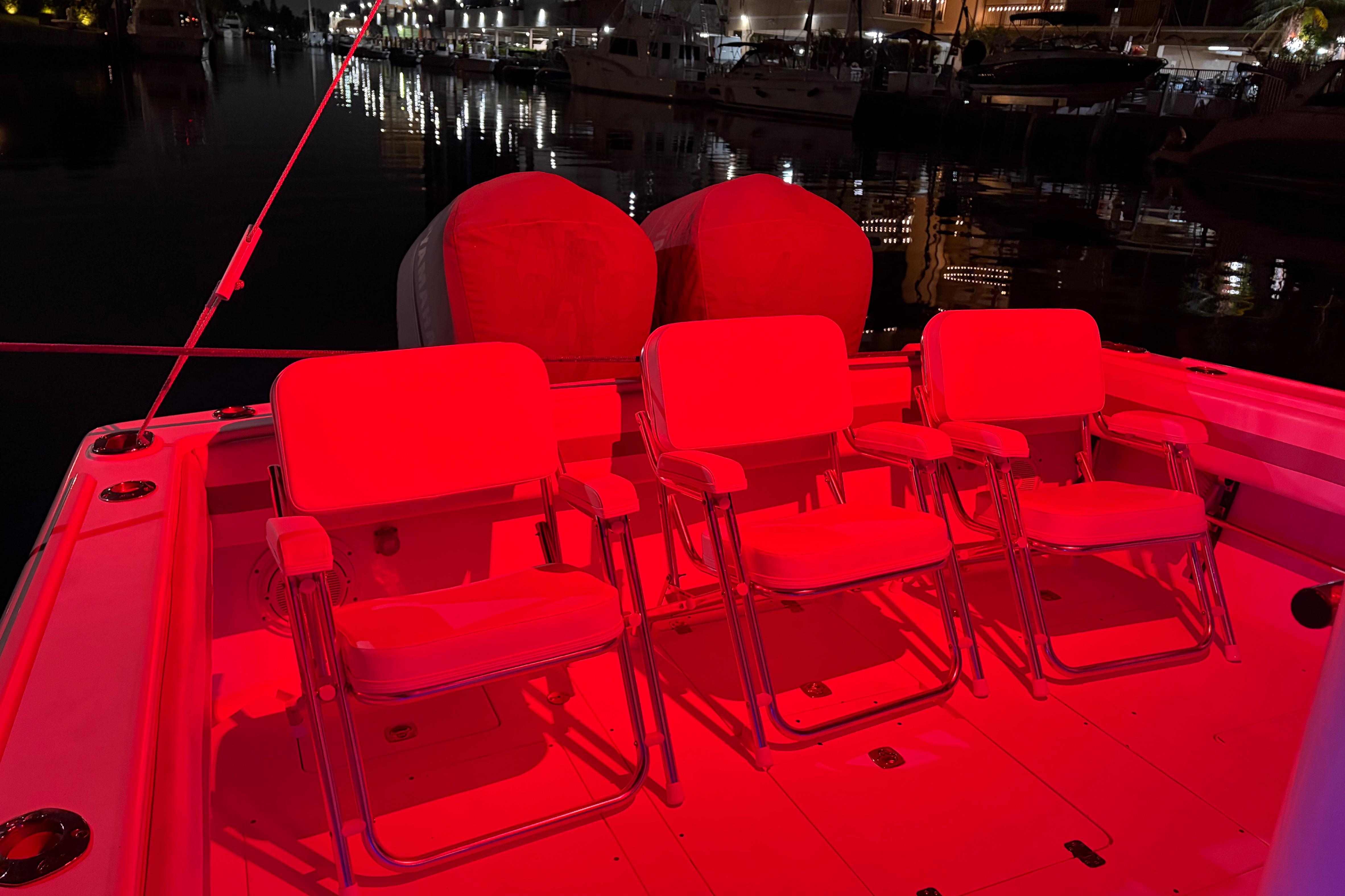 1998 Intrepid 339 Walkaround boat interior with red-lit seating at night in a marina.