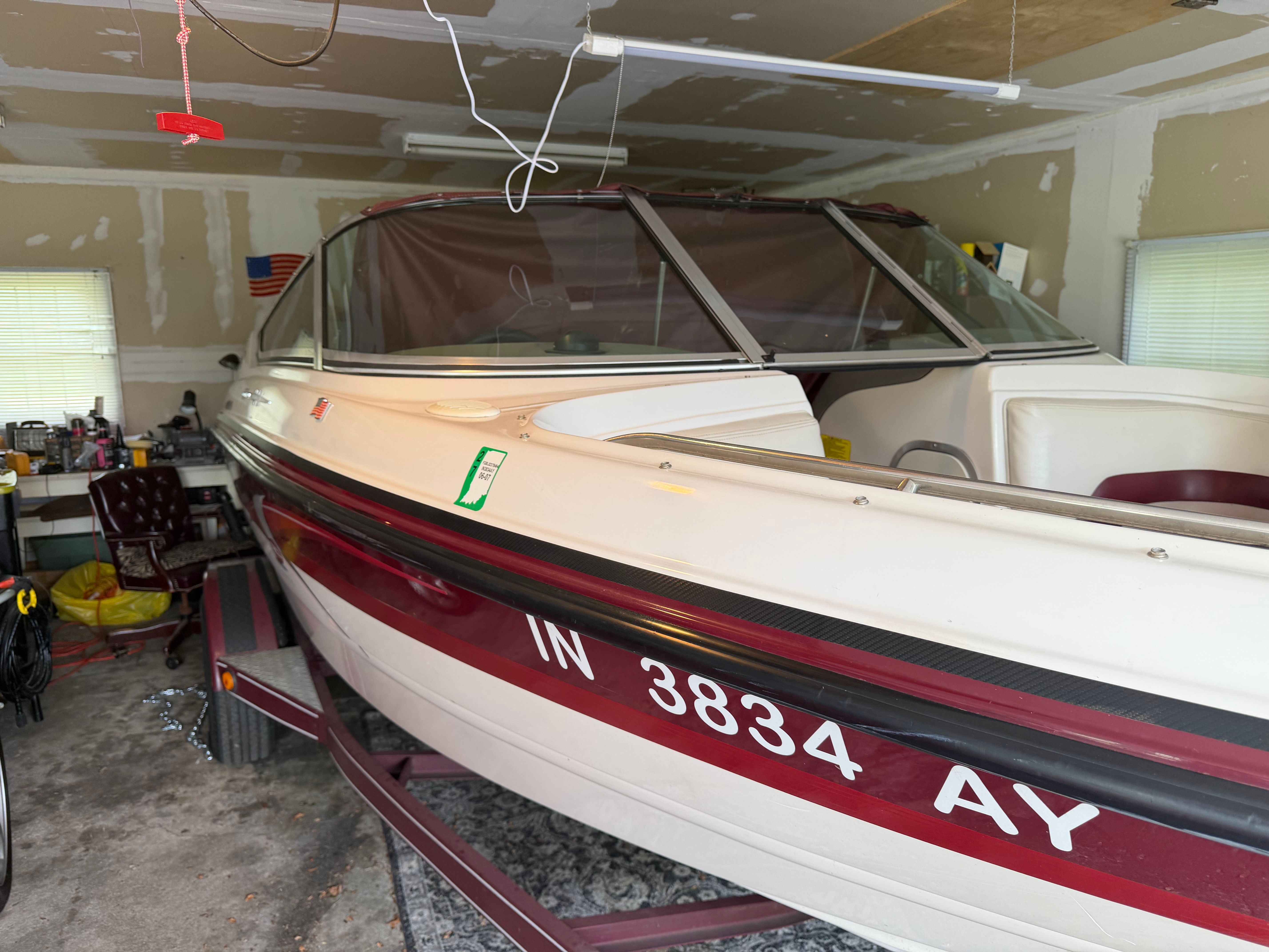 A 1994 Chaparral 1930 boat is in a garage on a trailer. It features a white and red paint scheme.