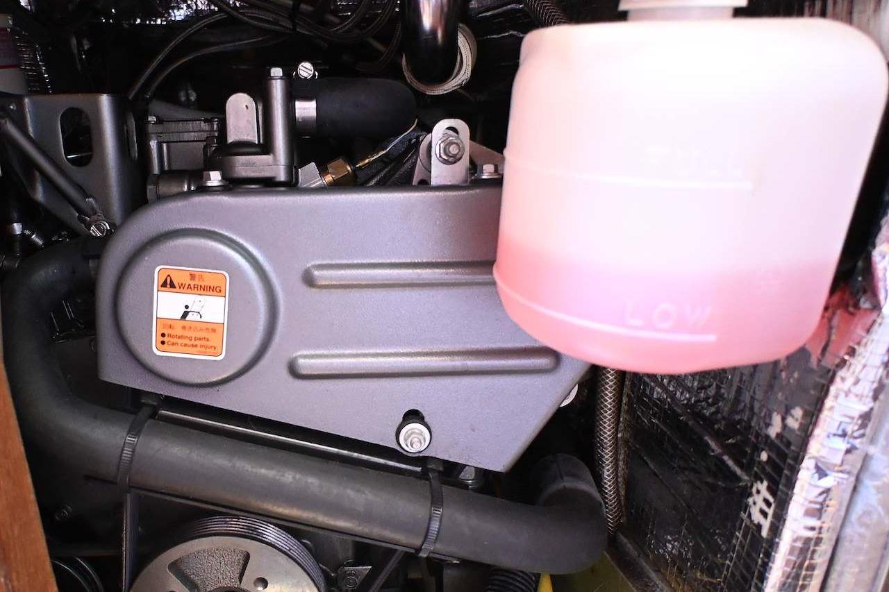 Engine compartment of a 1977 Mercator Offshore boat with visible coolant reservoir.