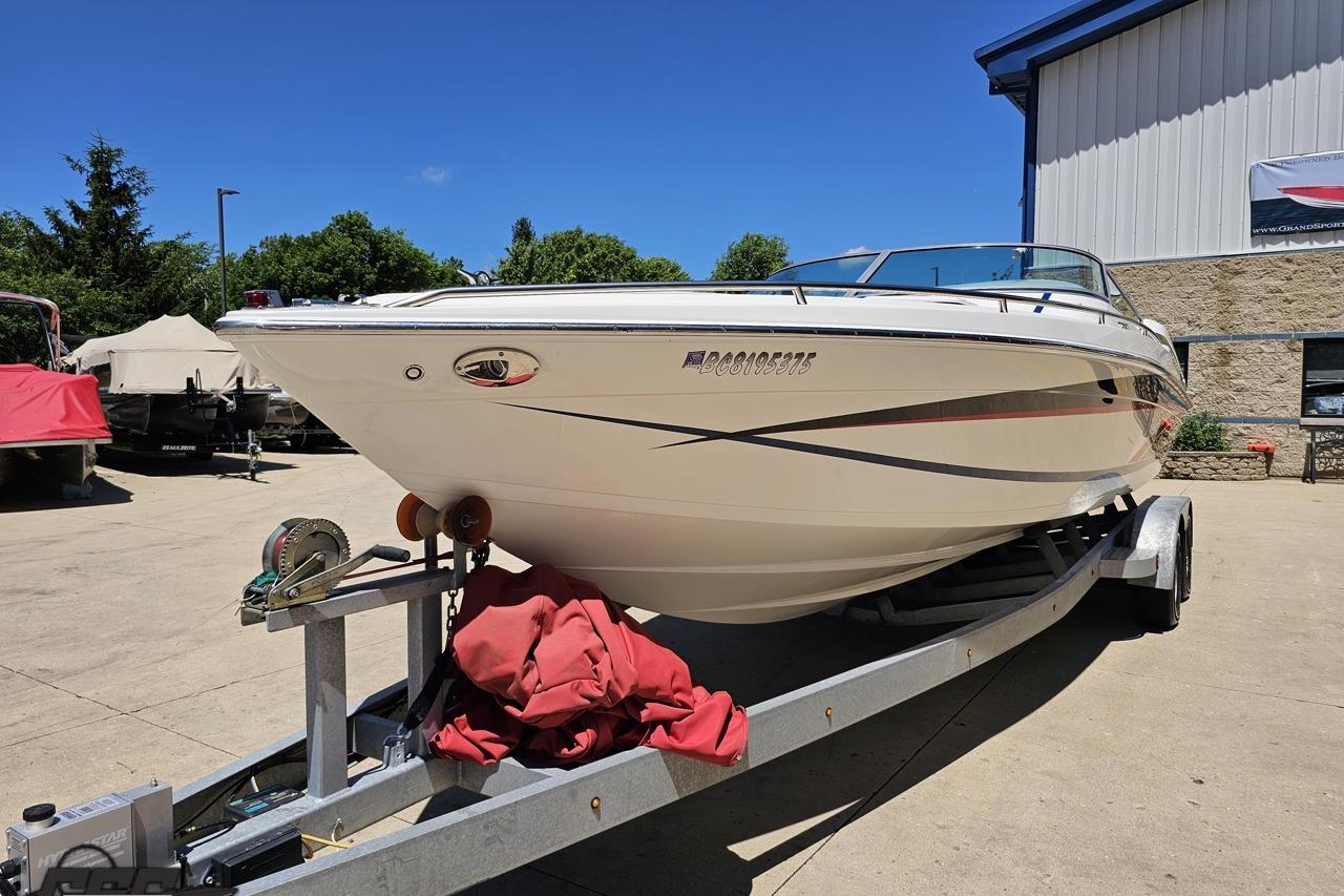 2005 Formula 271 FASTech boat on trailer, parked outdoors near a building.