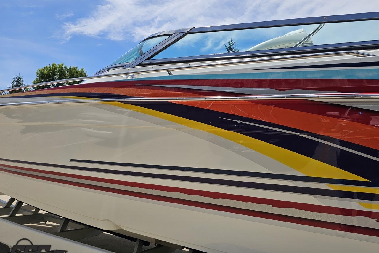 2002 Formula 382 FASTech boat with vibrant, colorful graphics under a clear blue sky.
