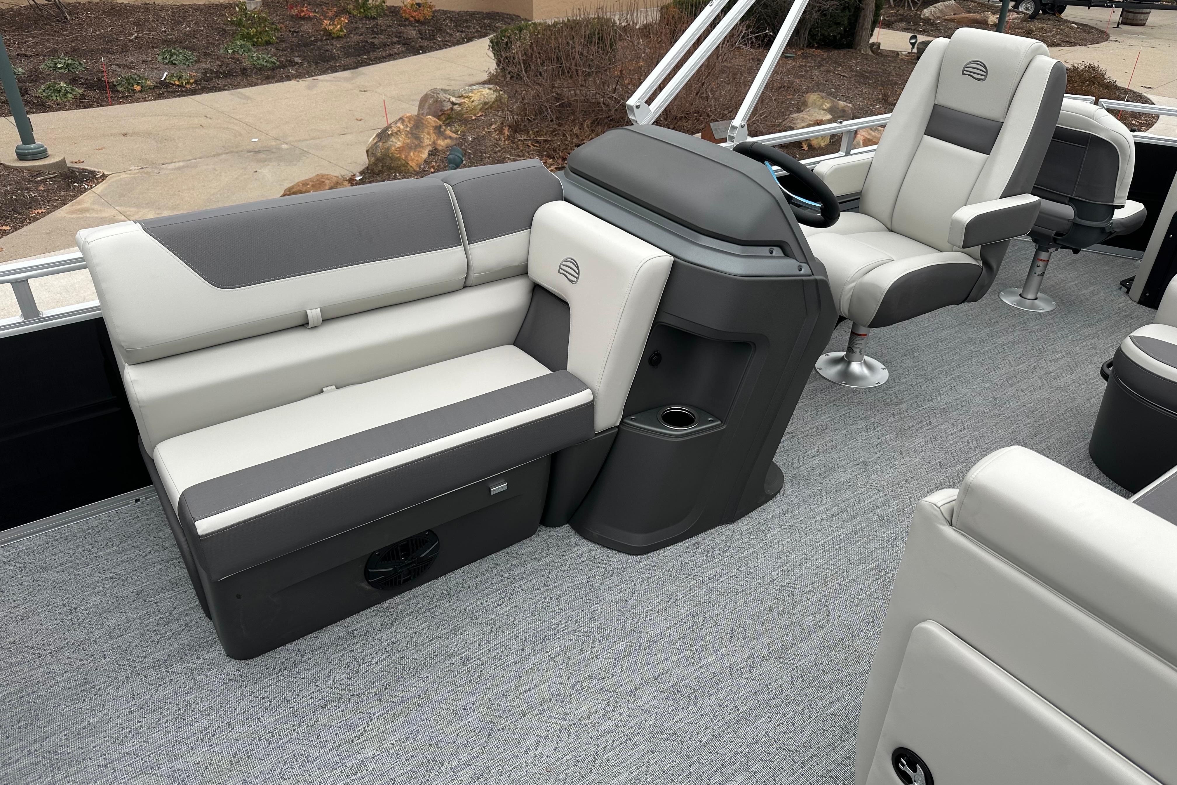 2026 Sun Tracker Fishin' Barge 22 DLX interior with gray seating and steering console.