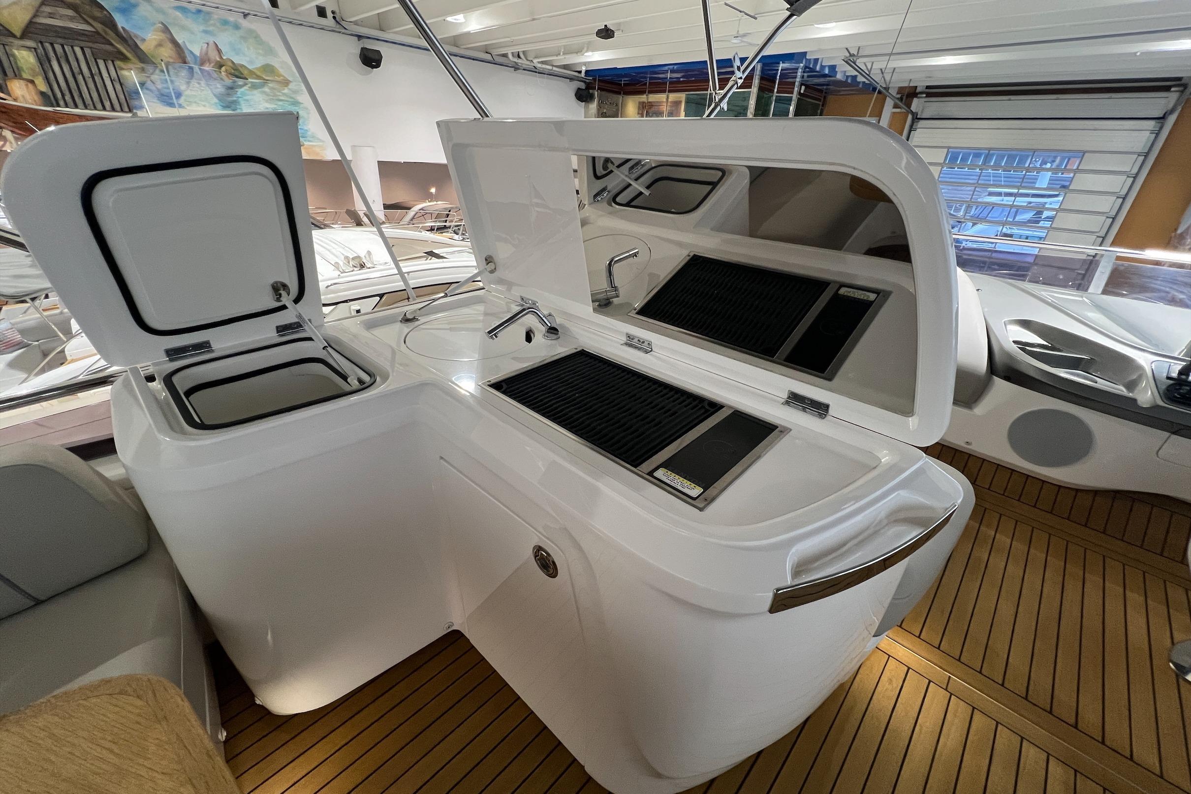 Luxury yacht galley on 2019 Princess F45 with grill and sink, wooden flooring.