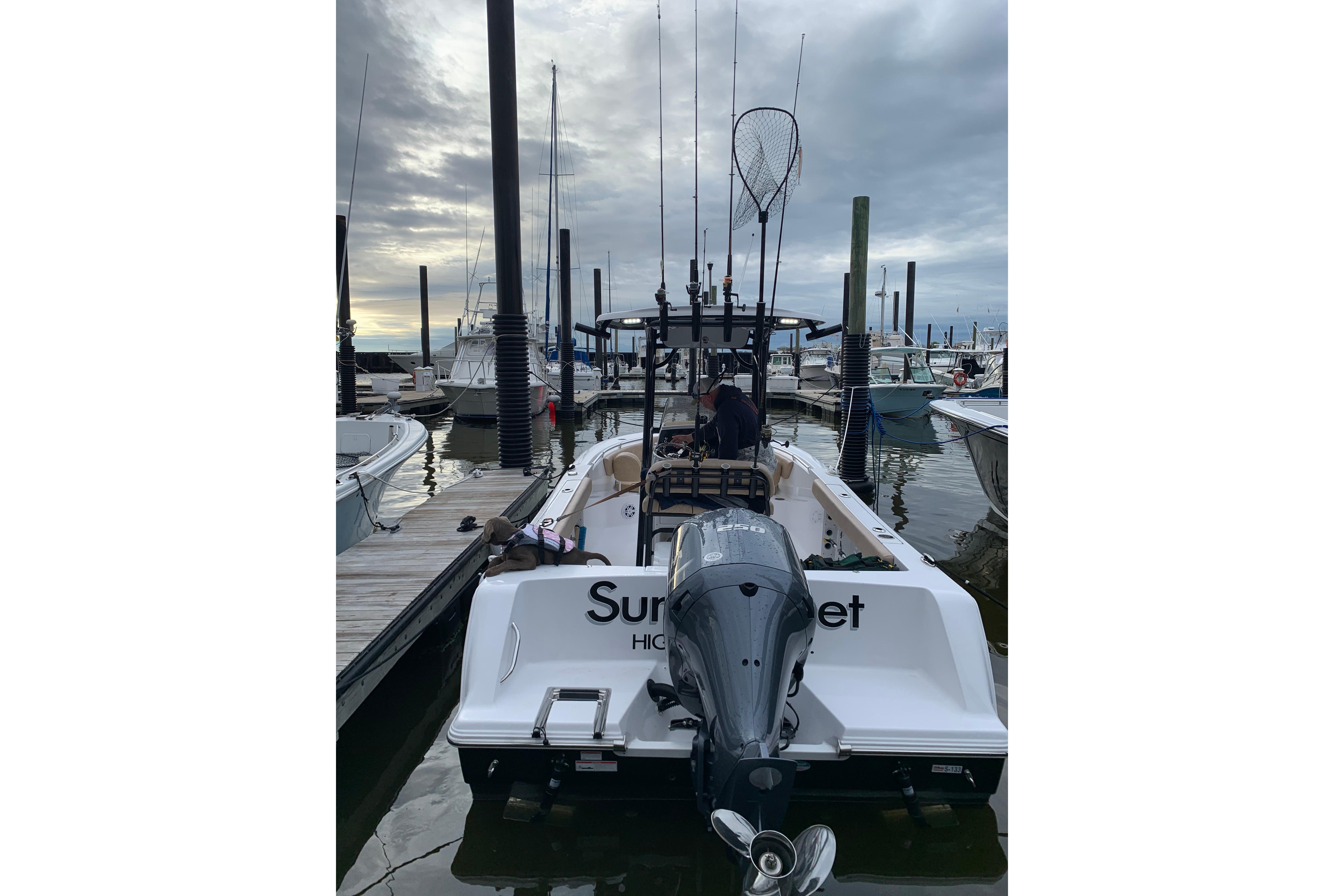 2019 Sportsman Heritage 231 Center Console boat docked at marina, overcast sky.