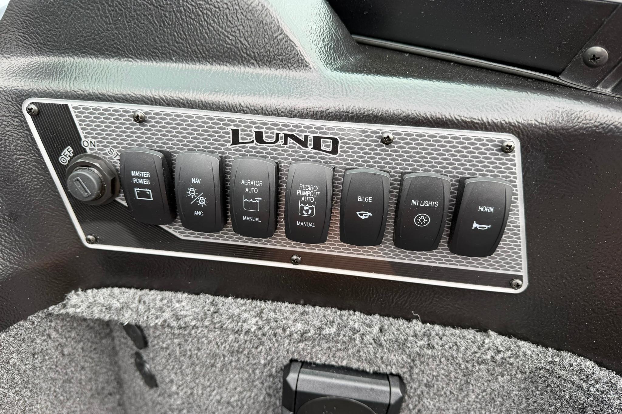Control panel of 2027 Lund 1875 Impact XS Sport boat with various switches.