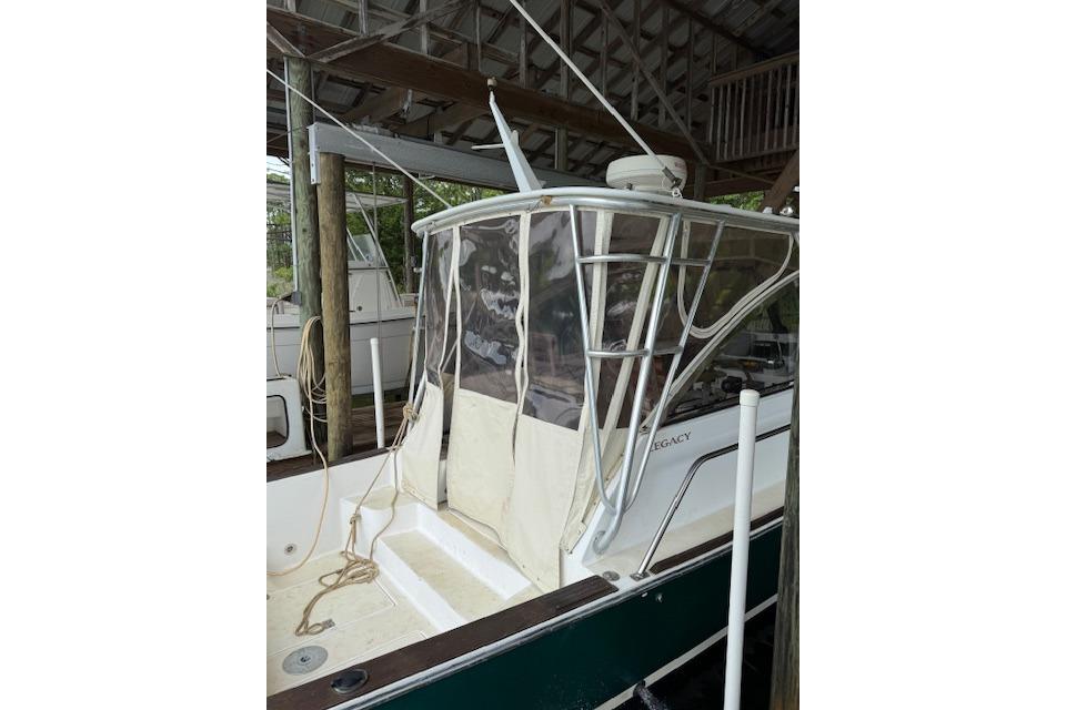 2001 Legacy Boat 28 Express docked, featuring a covered cockpit and sturdy frame.