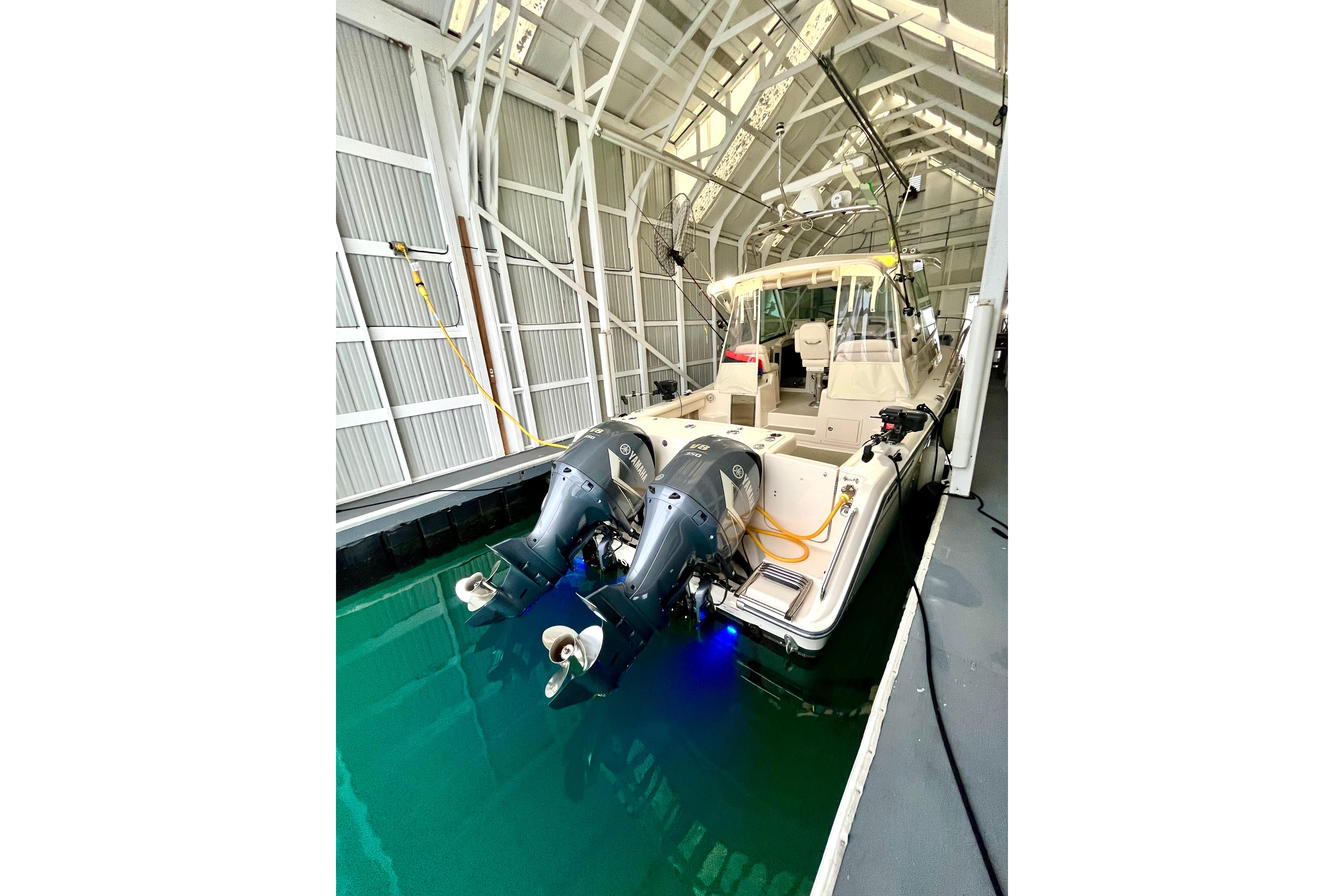 2017 Grady-White Express 330 boat docked in a covered marina with dual outboard engines.
