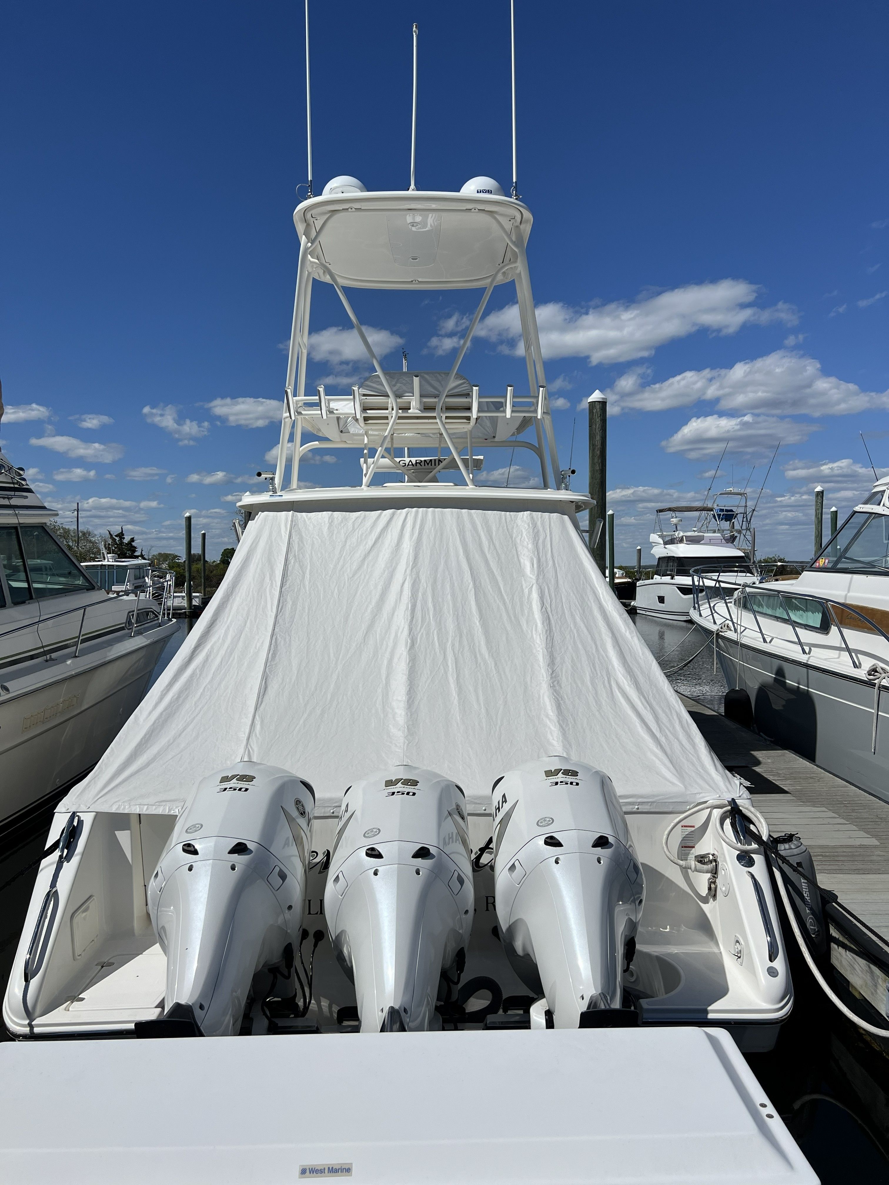 2021 Pursuit OS 385 Offshore with triple outboard engines docked.