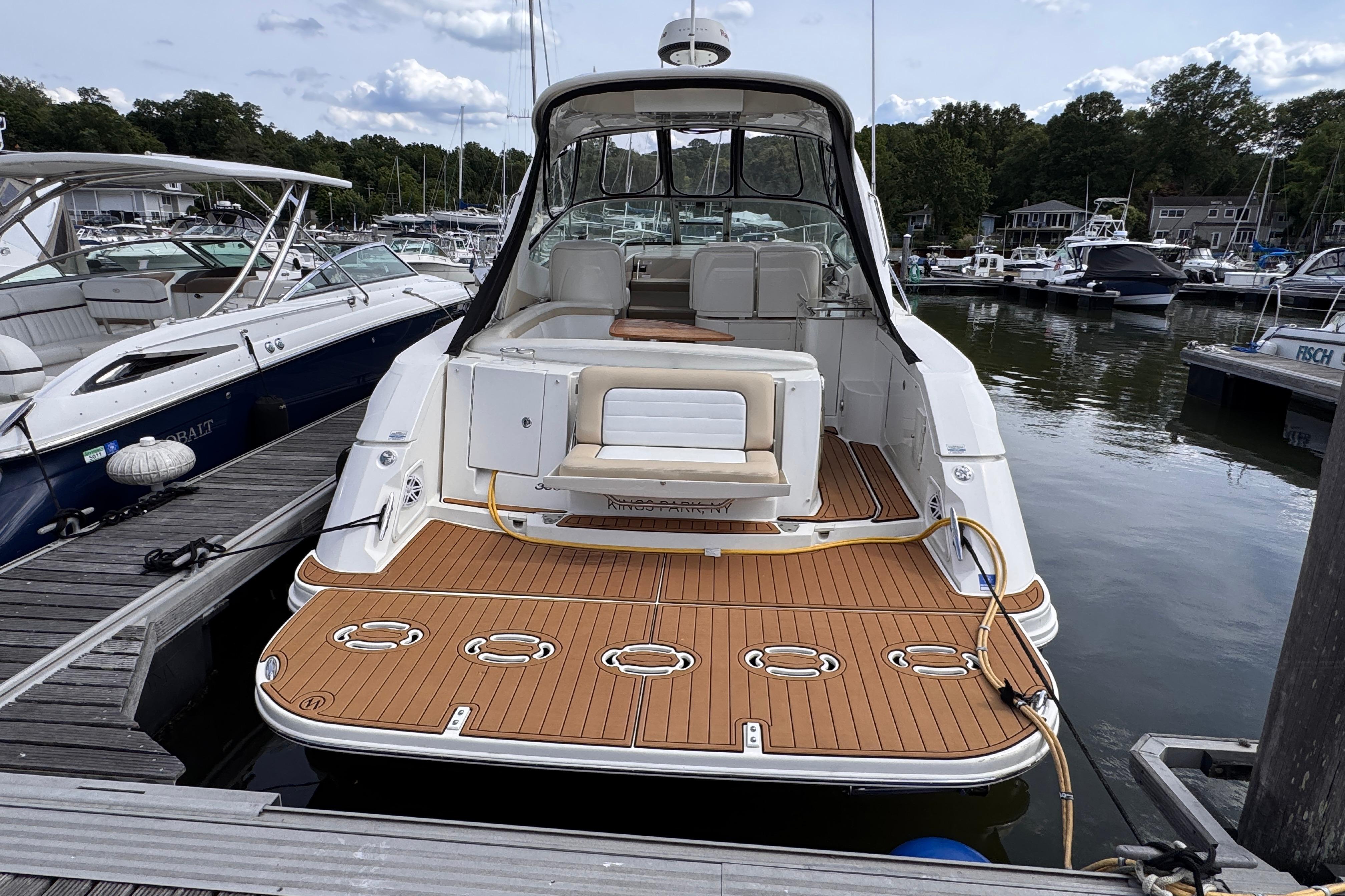 2008 Sea Ray Sundancer 350 docked at marina, showcasing spacious deck and seating area.