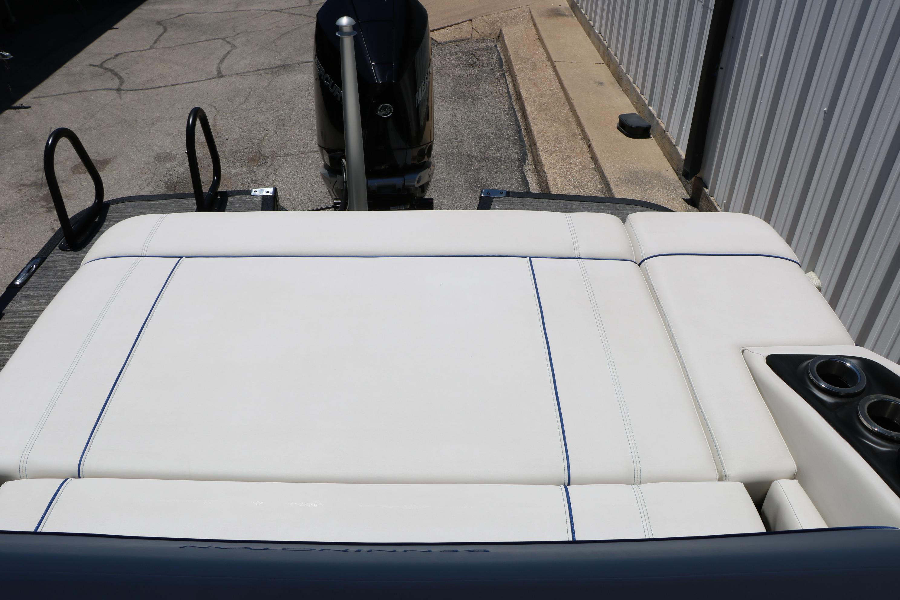 2024 Bennington 23 RX Swingback boat with white cushioned seating and cup holders.