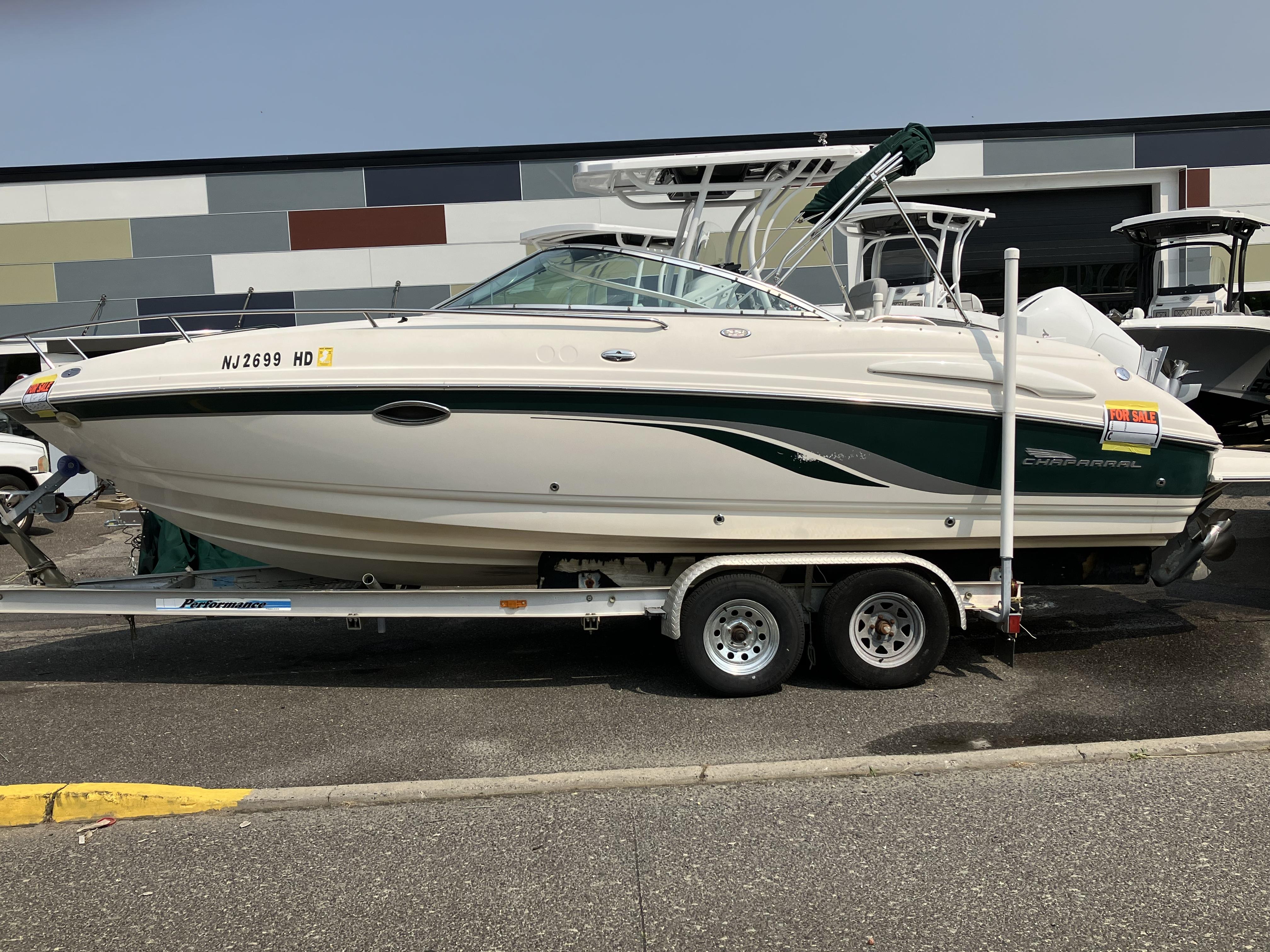 A 2001 Chaparral 235 SSi boat on a trailer, parked in a lot.