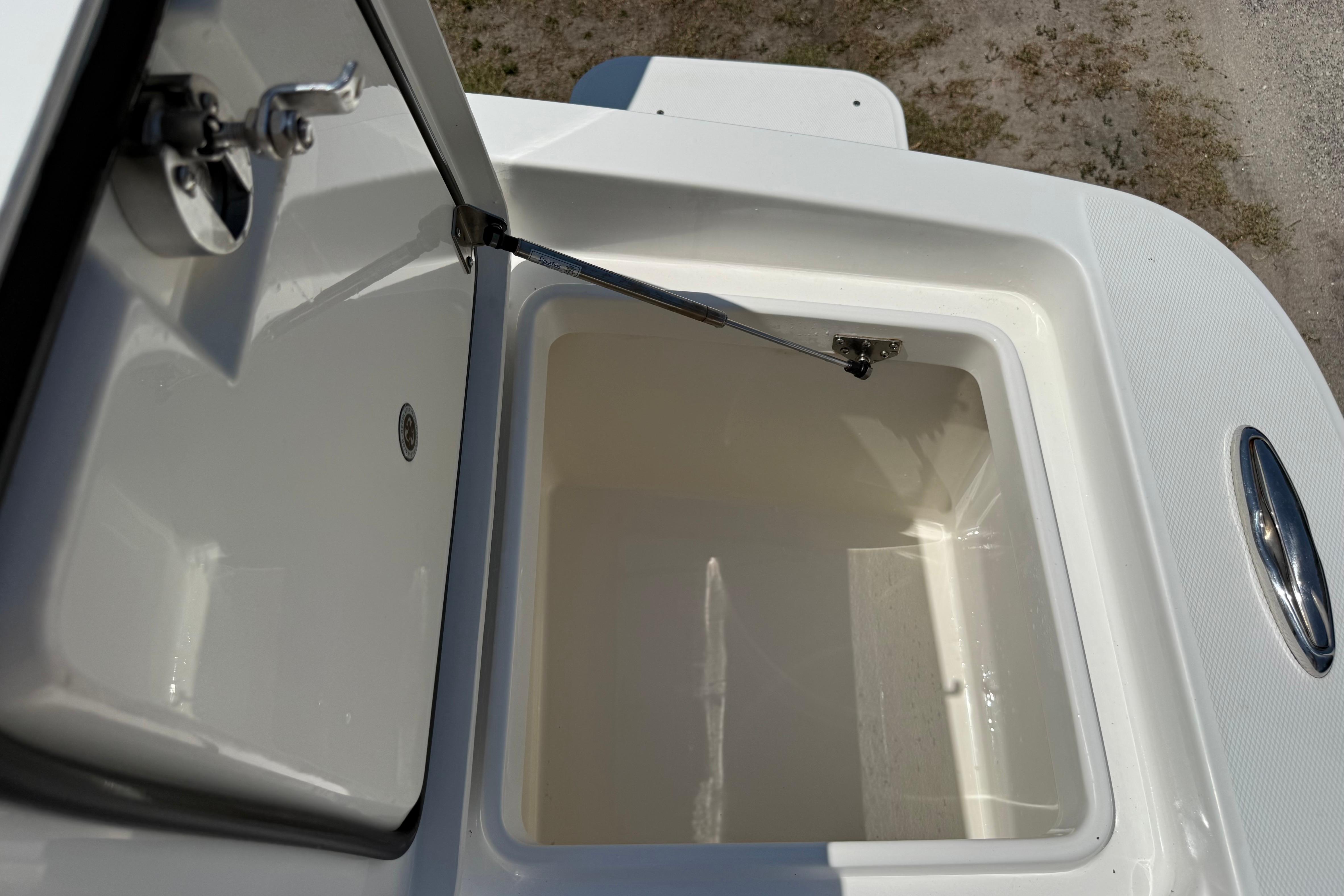Open storage compartment on 2023 Regulator 26XO boat, showcasing interior space.