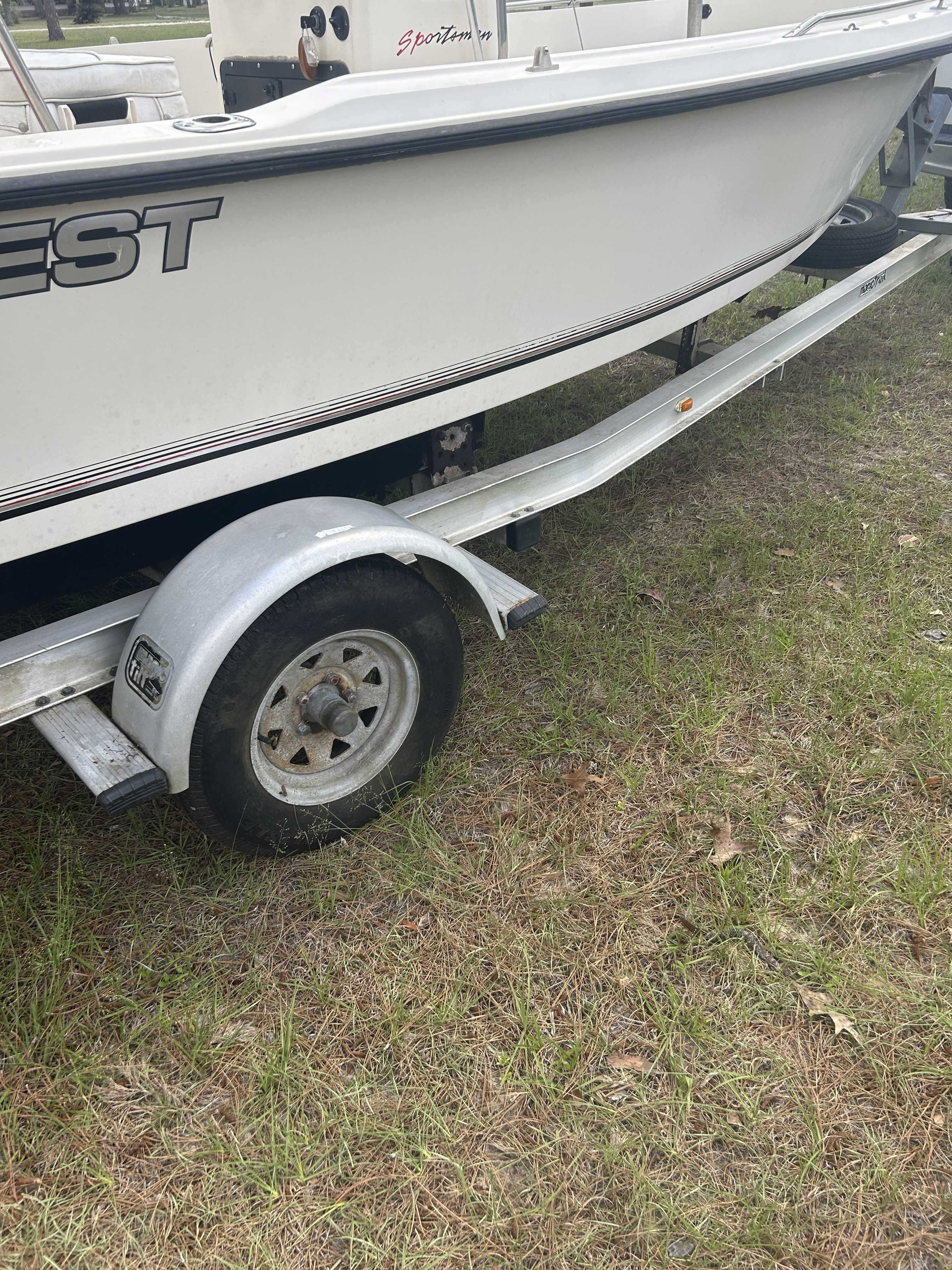 1993 Key West 1720 boat on trailer in grass.
