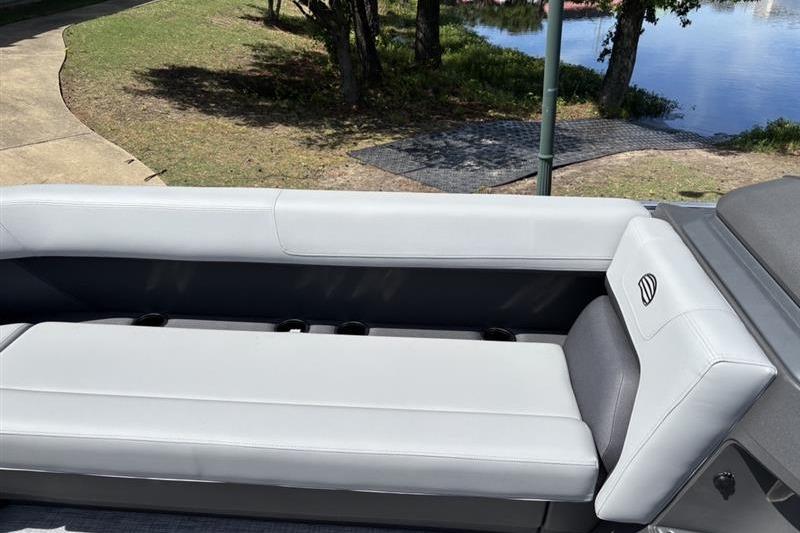 2026 Sun Tracker Party Barge 18 DLX interior seating by a lakeside.