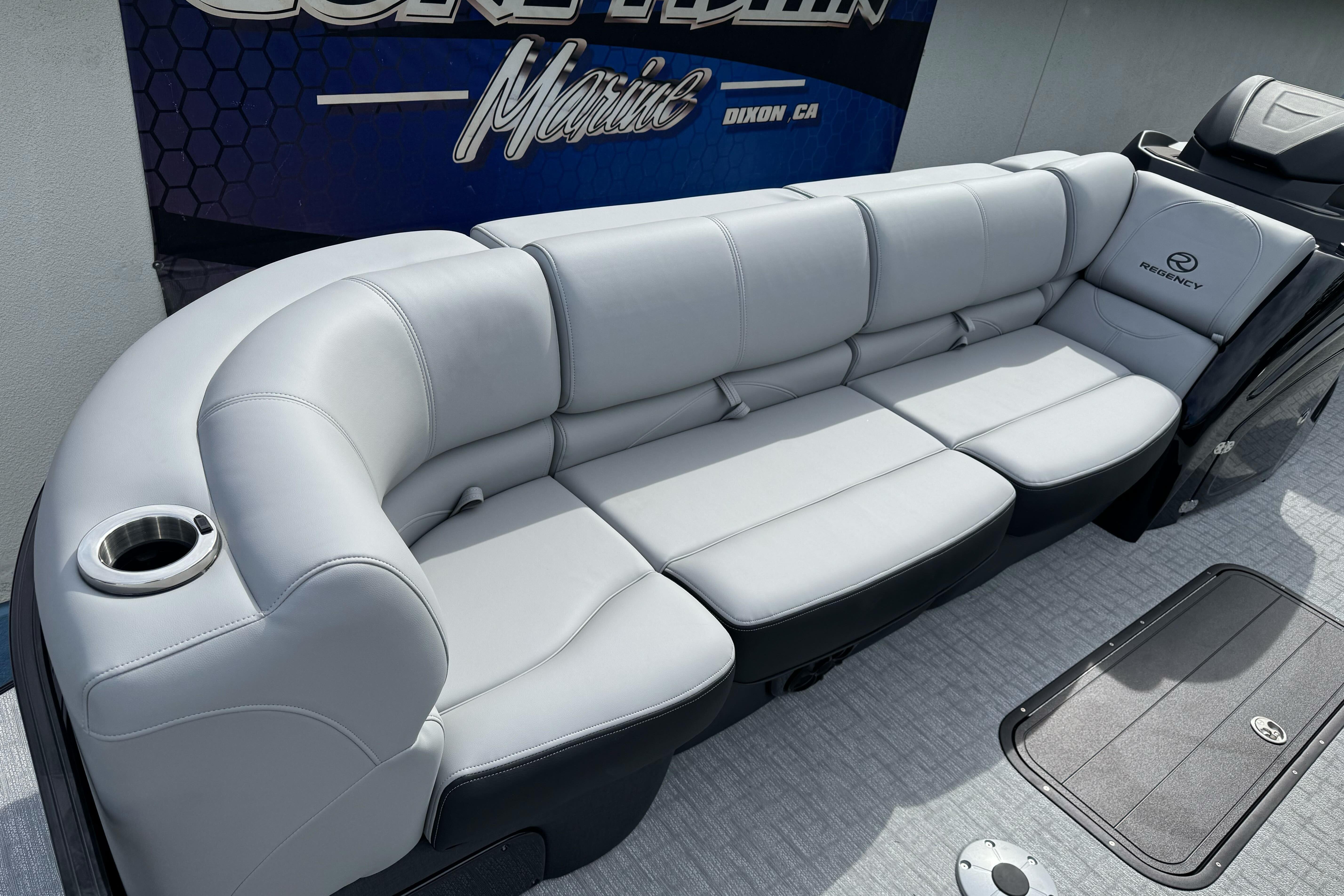 Luxurious seating on 2026 Regency 250 DL boat with sleek design and cup holder.