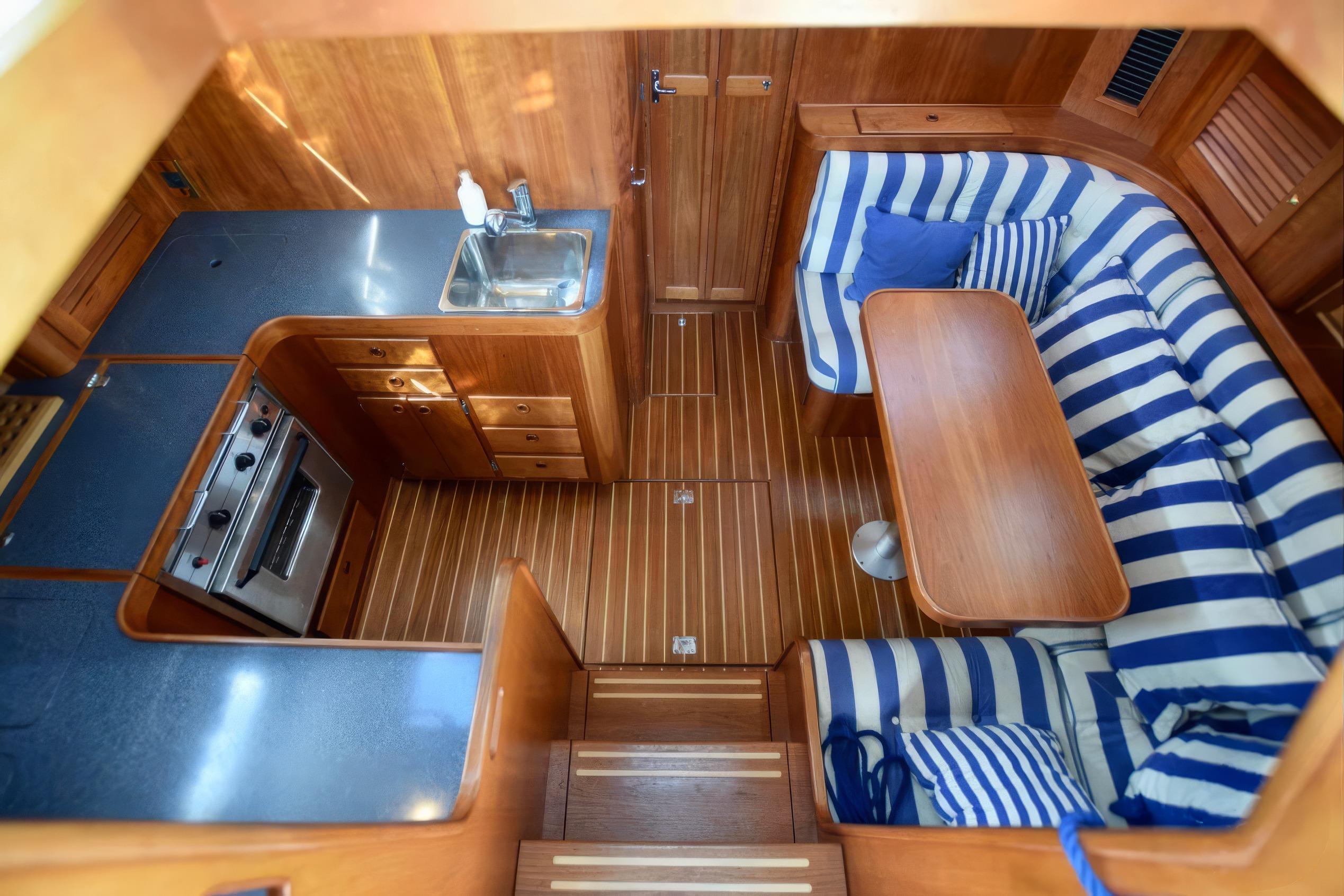 Interior of 2001 Sabreline 36 Express yacht with striped seating and compact kitchen.