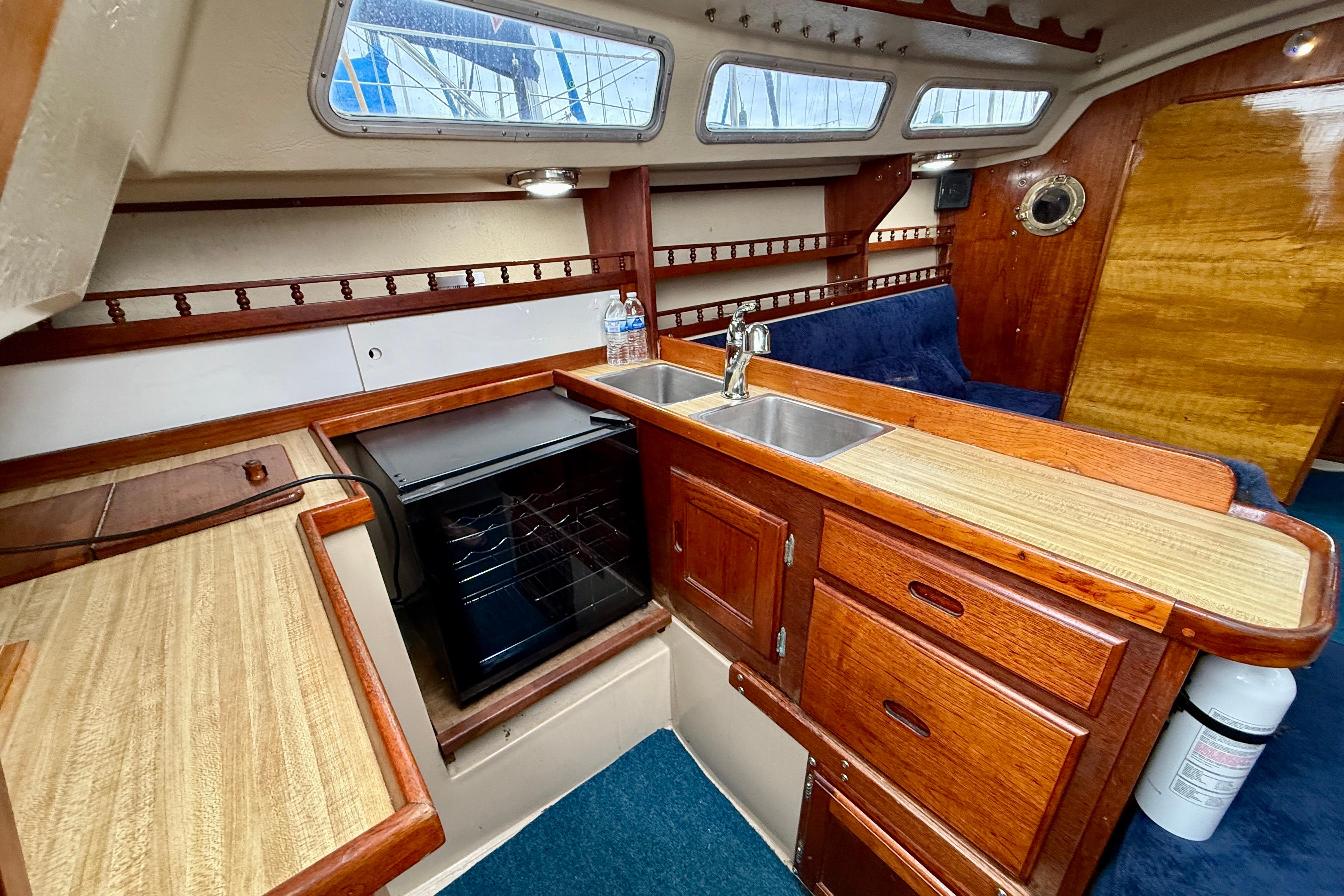 1982 Catalina 30 yacht interior with wooden cabinetry, sink, and compact kitchen area.