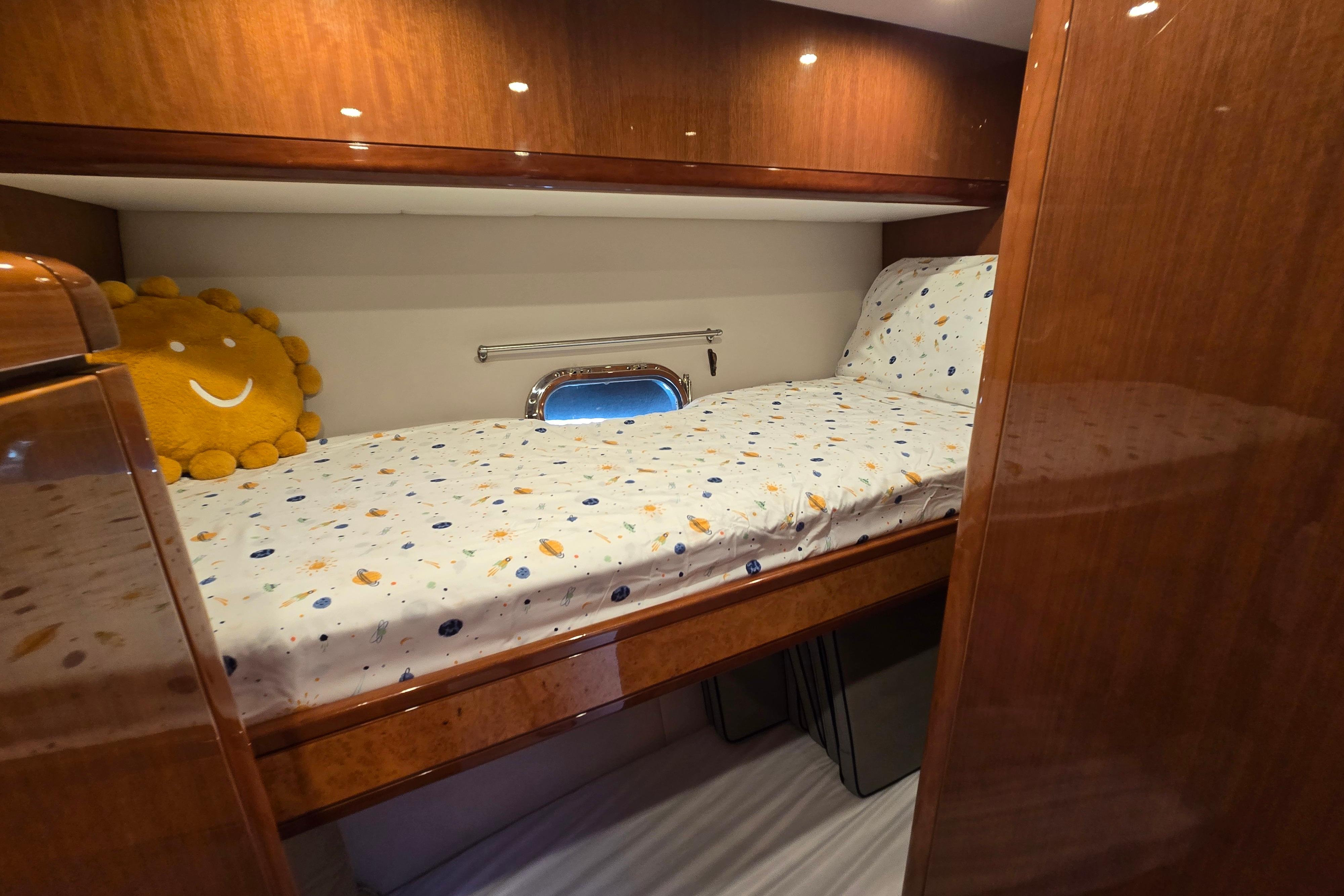Cozy cabin bed in 2004 Grand Harbour 58 yacht with wooden finish and decorative pillow.