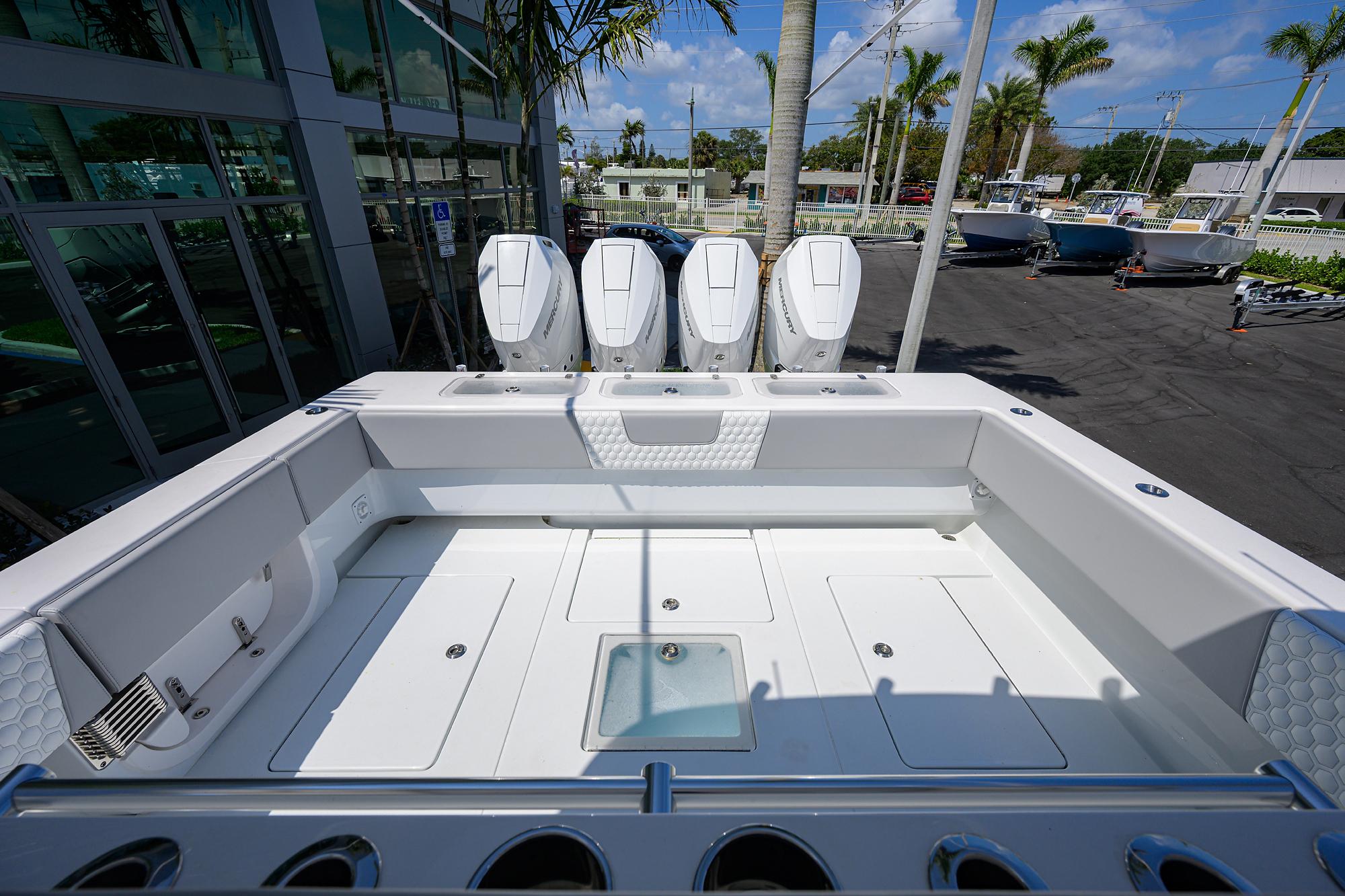2025 Contender 44ST boat with four powerful outboard engines, docked in a marina.
