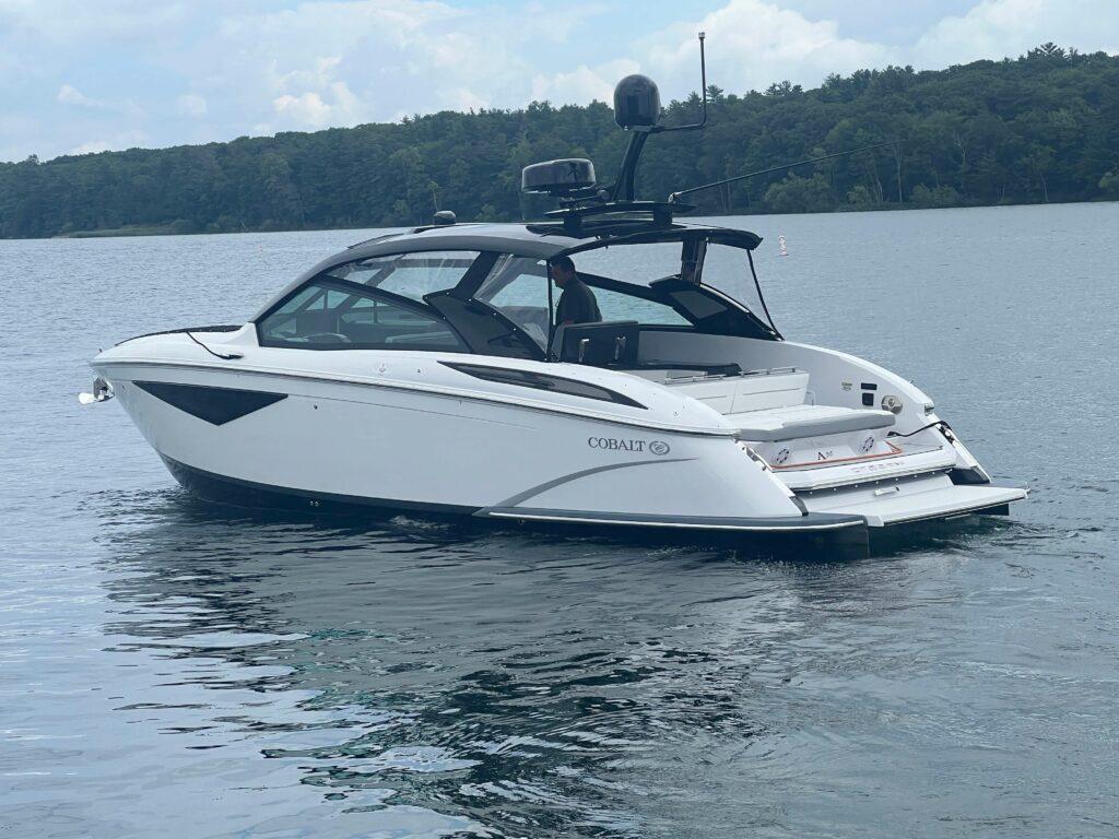 2020 Cobalt A36BR boat on a serene lake with forested shoreline.