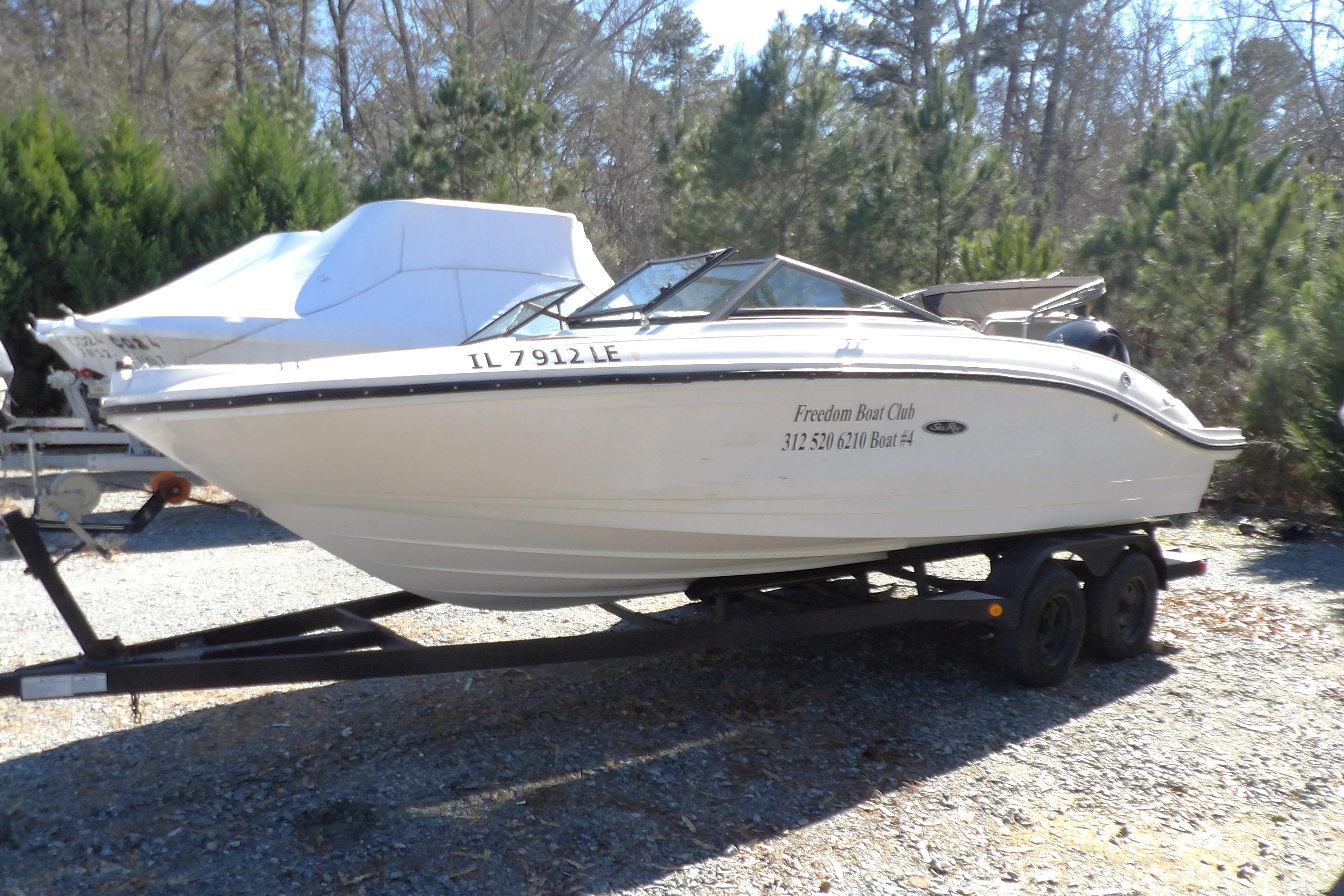 2023 Searay 210 SPO boat on trailer, parked outdoors with trees in background.