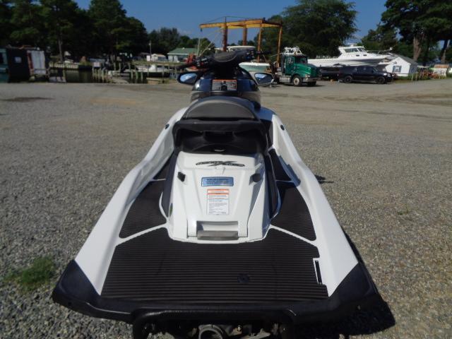 2015 Yamaha WaveRunner FX Cruiser H/O parked on gravel near boats and trees.