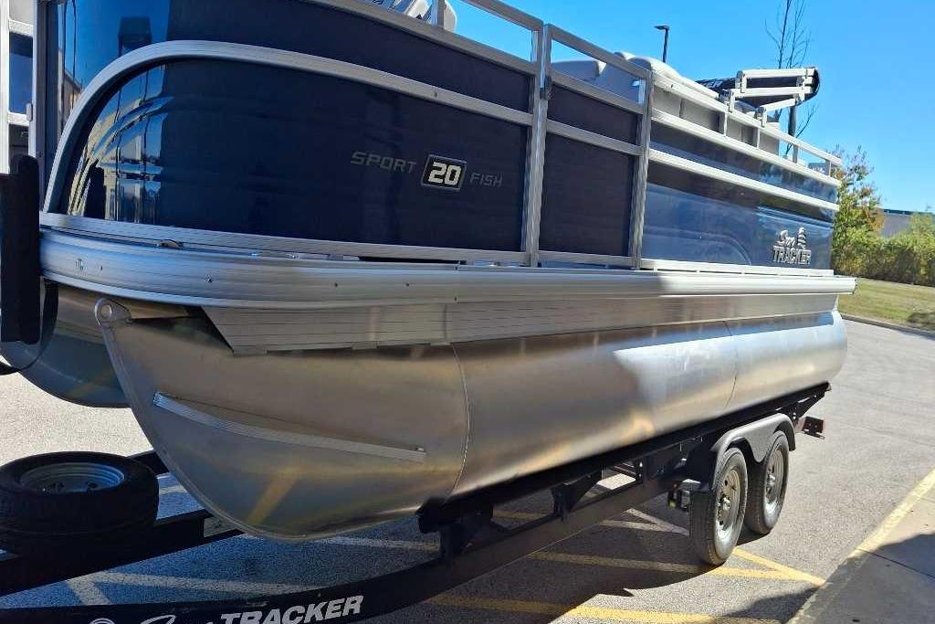 2026 Sun Tracker SportFish 20 DLX pontoon boat on trailer, side view.