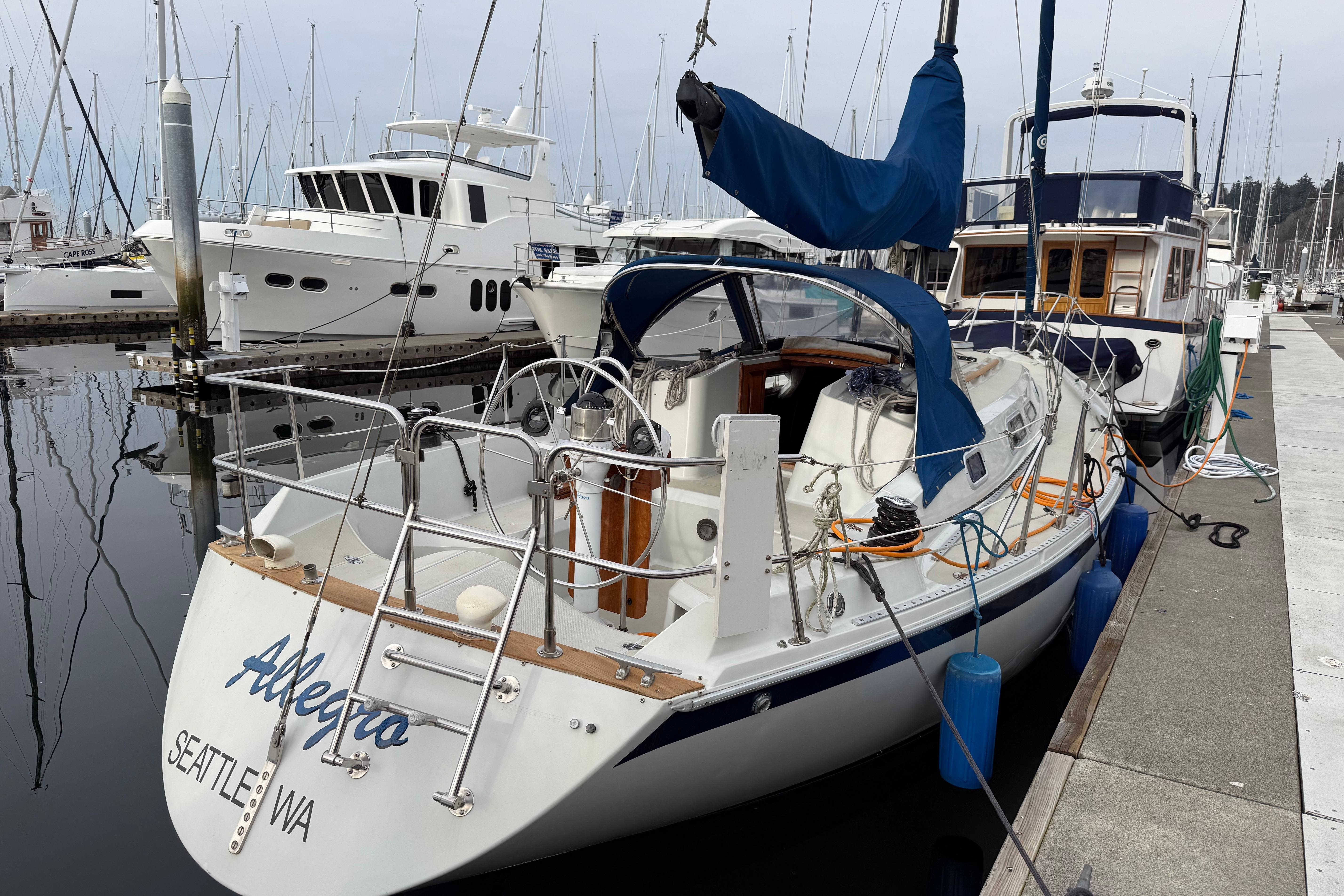 1988 Ericson 32-200 sailboat docked in marina, Seattle, WA, with blue sail cover.
