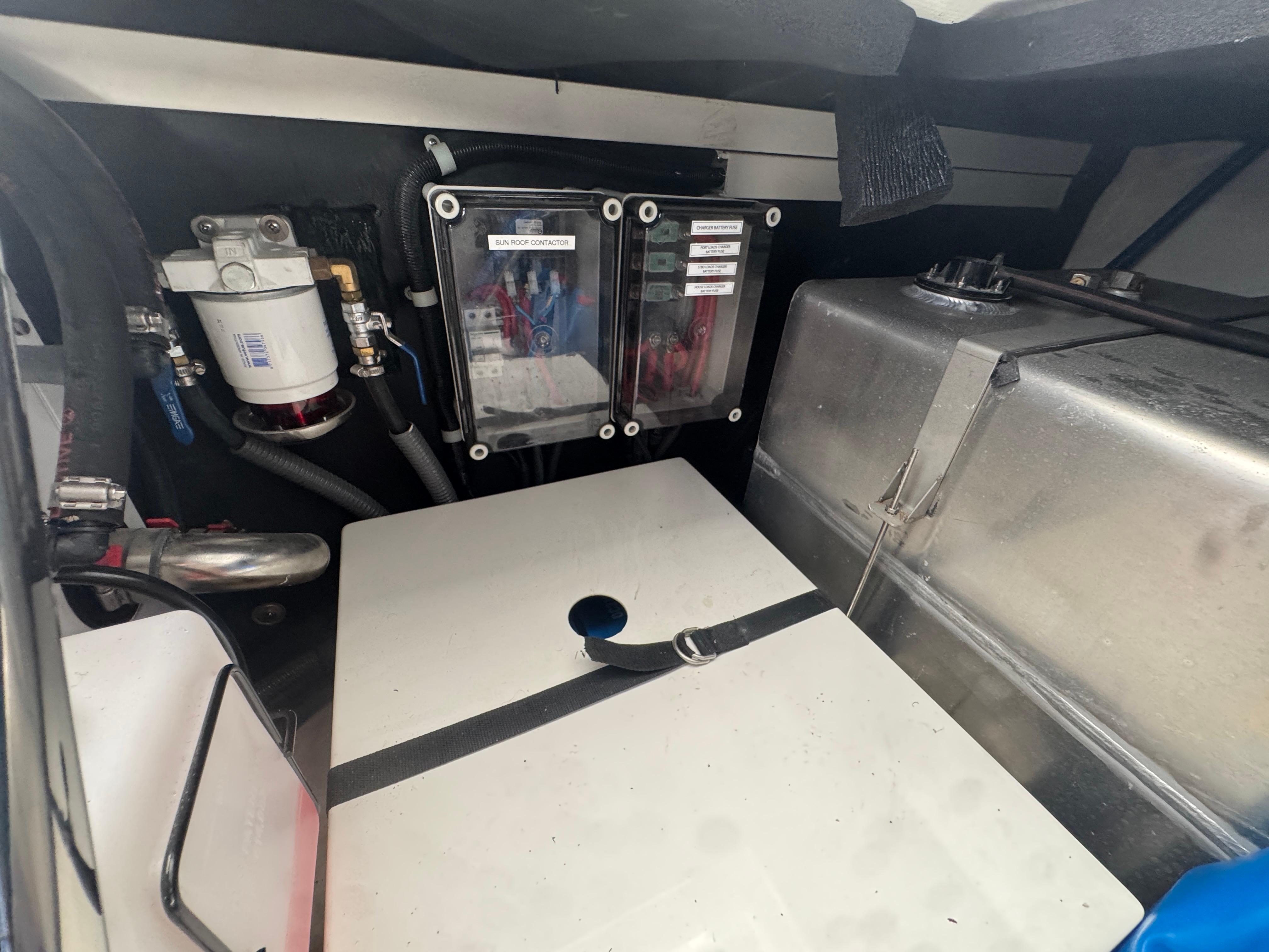 Engine compartment of 2023 Schaefer 375 HT boat, featuring fuel system and storage components.