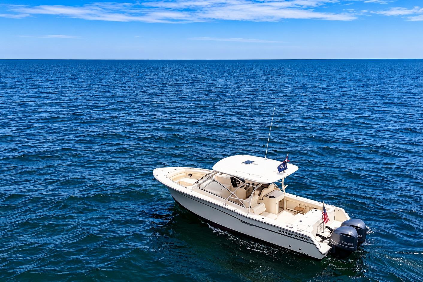 2019 Grady-White Freedom 307 boat cruising on open ocean under clear blue sky.