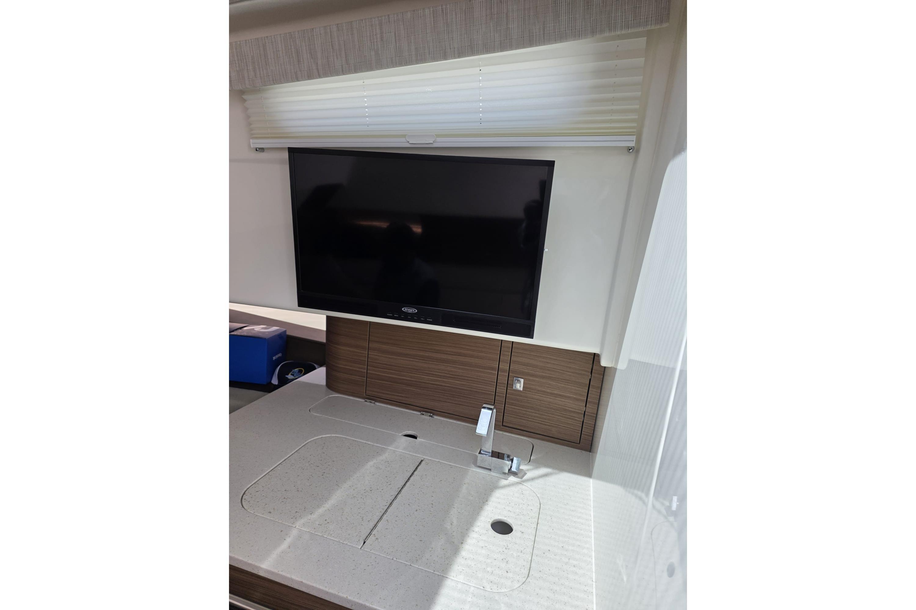 Interior of 2020 Boston Whaler 420 Outrage featuring a modern TV and sleek countertop.