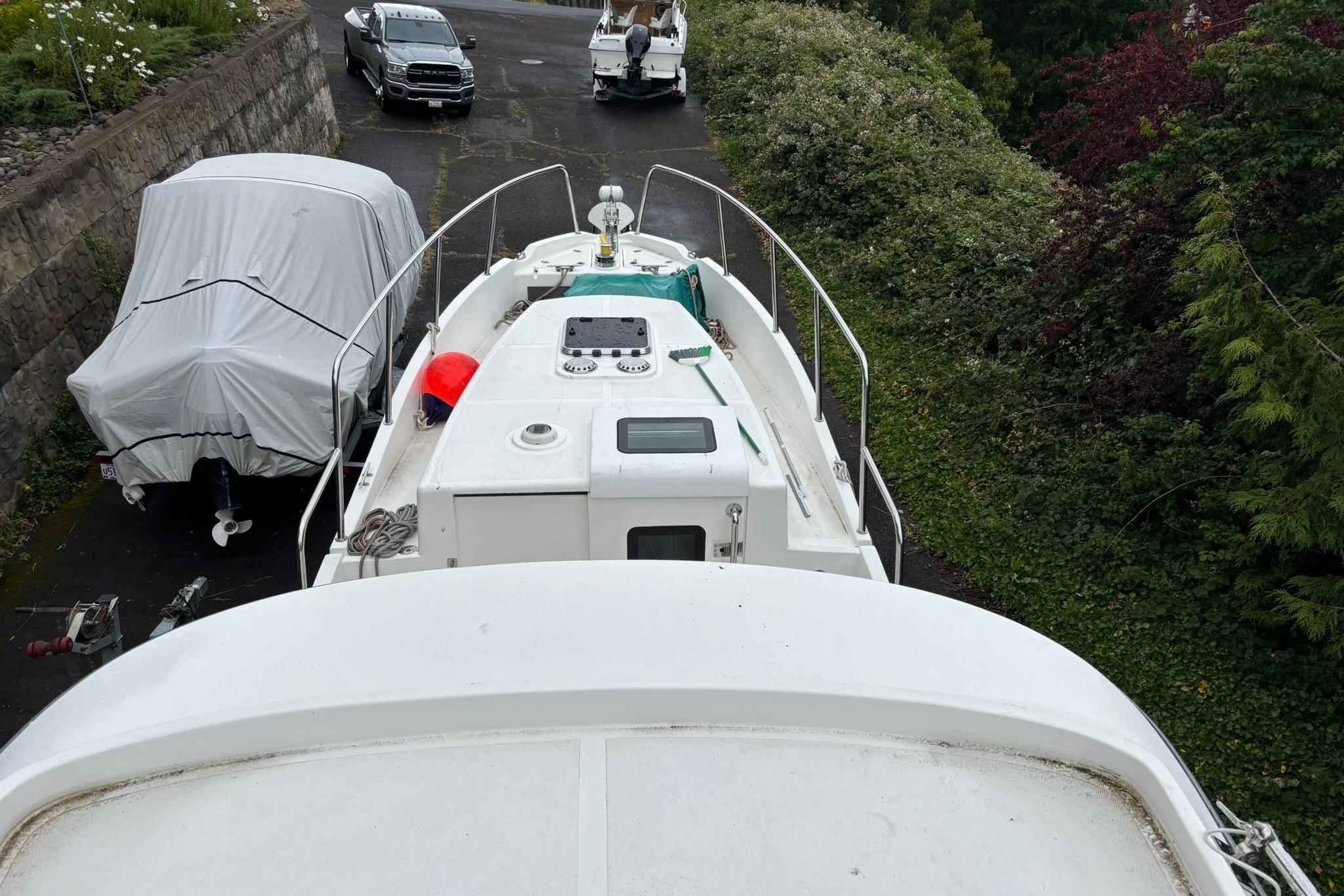 SeaPiper 35 boat from 2020 on a driveway, surrounded by greenery and parked vehicles.