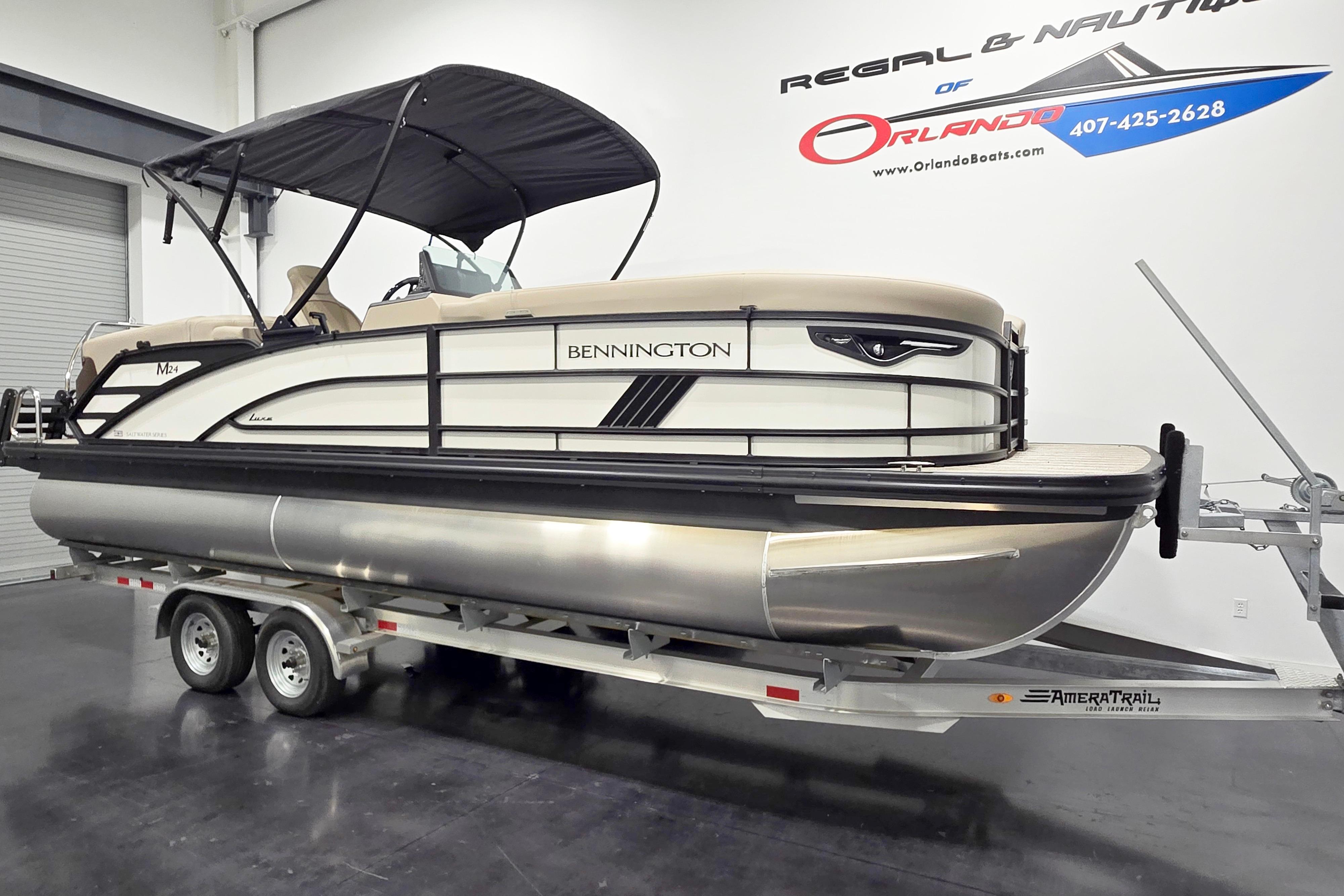 2026 Bennington 24 M pontoon boat on trailer in showroom setting.