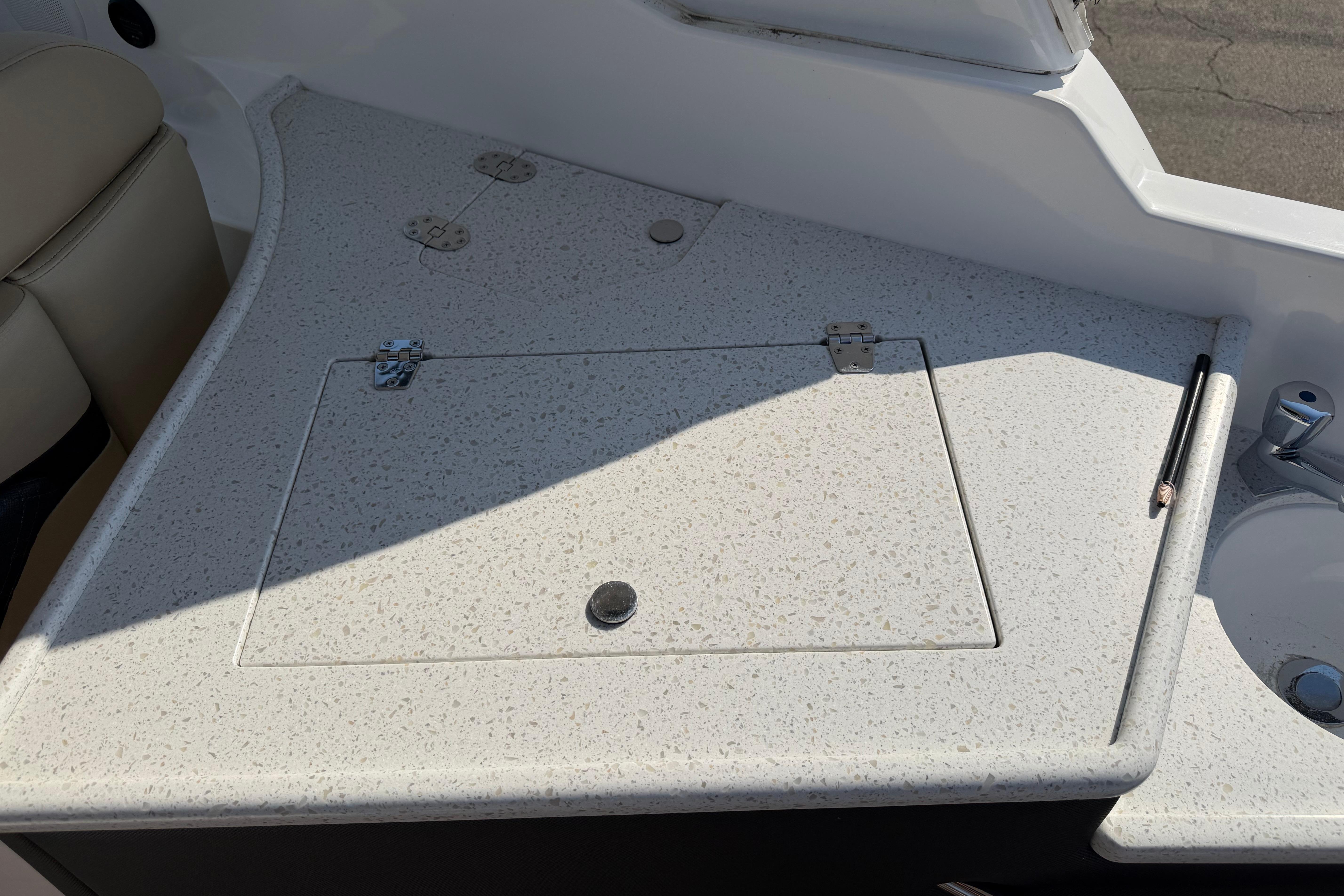 2019 Rinker EX 320 boat interior with speckled countertop and storage hatch.