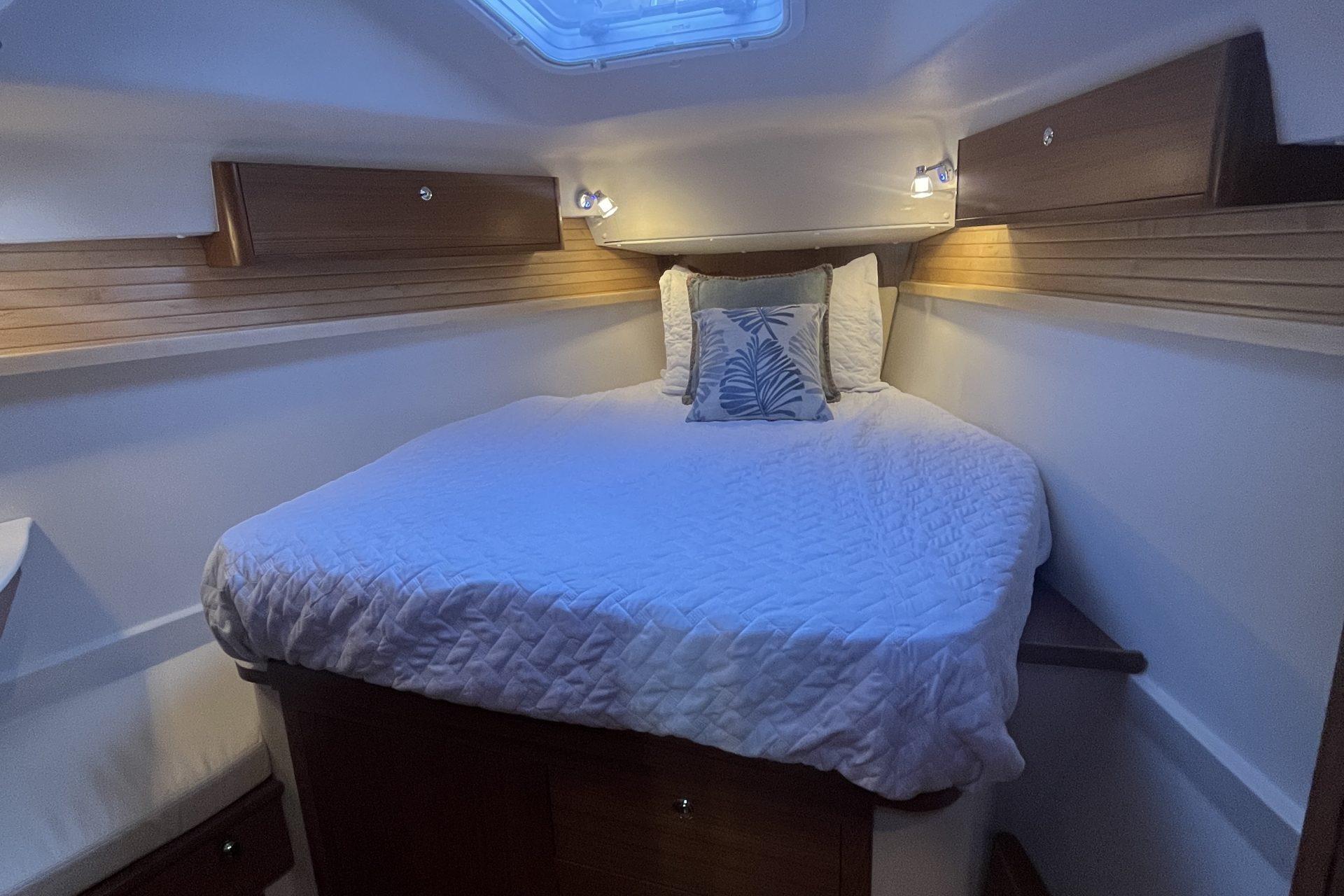 Cozy cabin interior of 2026 Catalina 386 sailboat with comfortable bedding and ambient lighting.