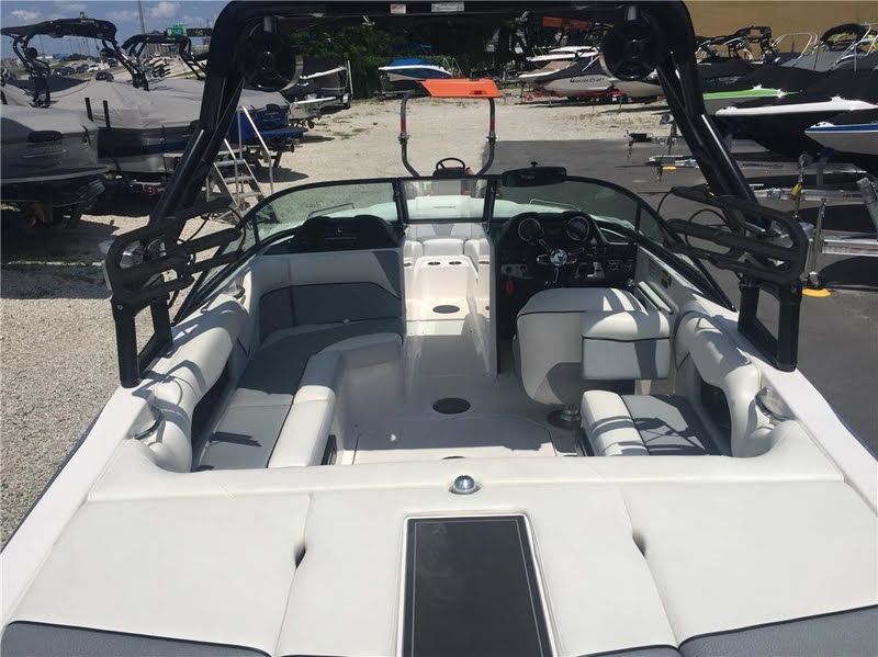 The image shows a 2016 Moomba Mondo boat with a spacious interior and modern controls.