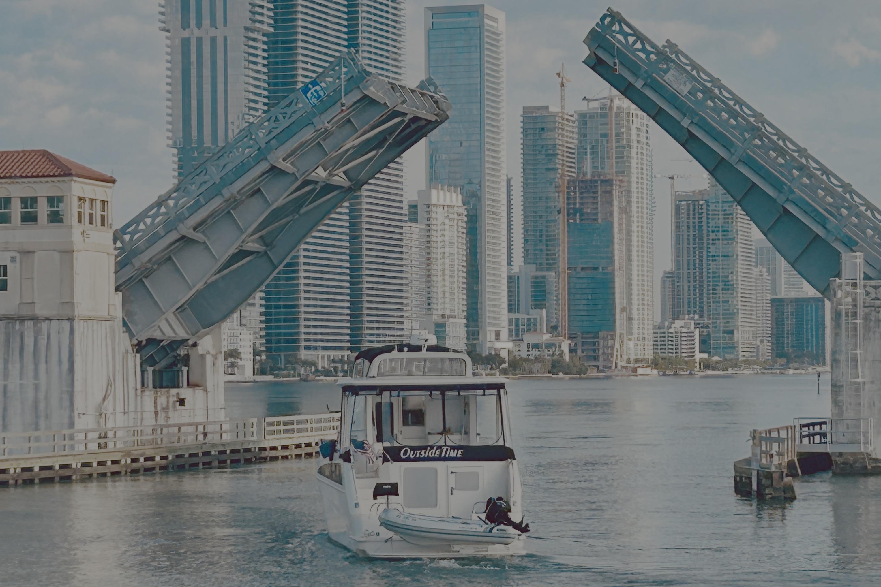 2006 Carver 43 Motor Yacht passing under a raised drawbridge in an urban skyline setting.