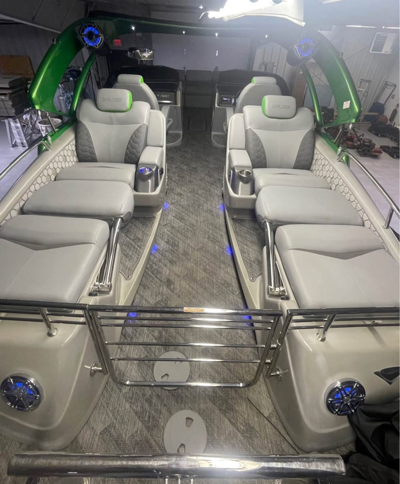 Interior view of a luxury pontoon boat with gray seating and blue lighting.