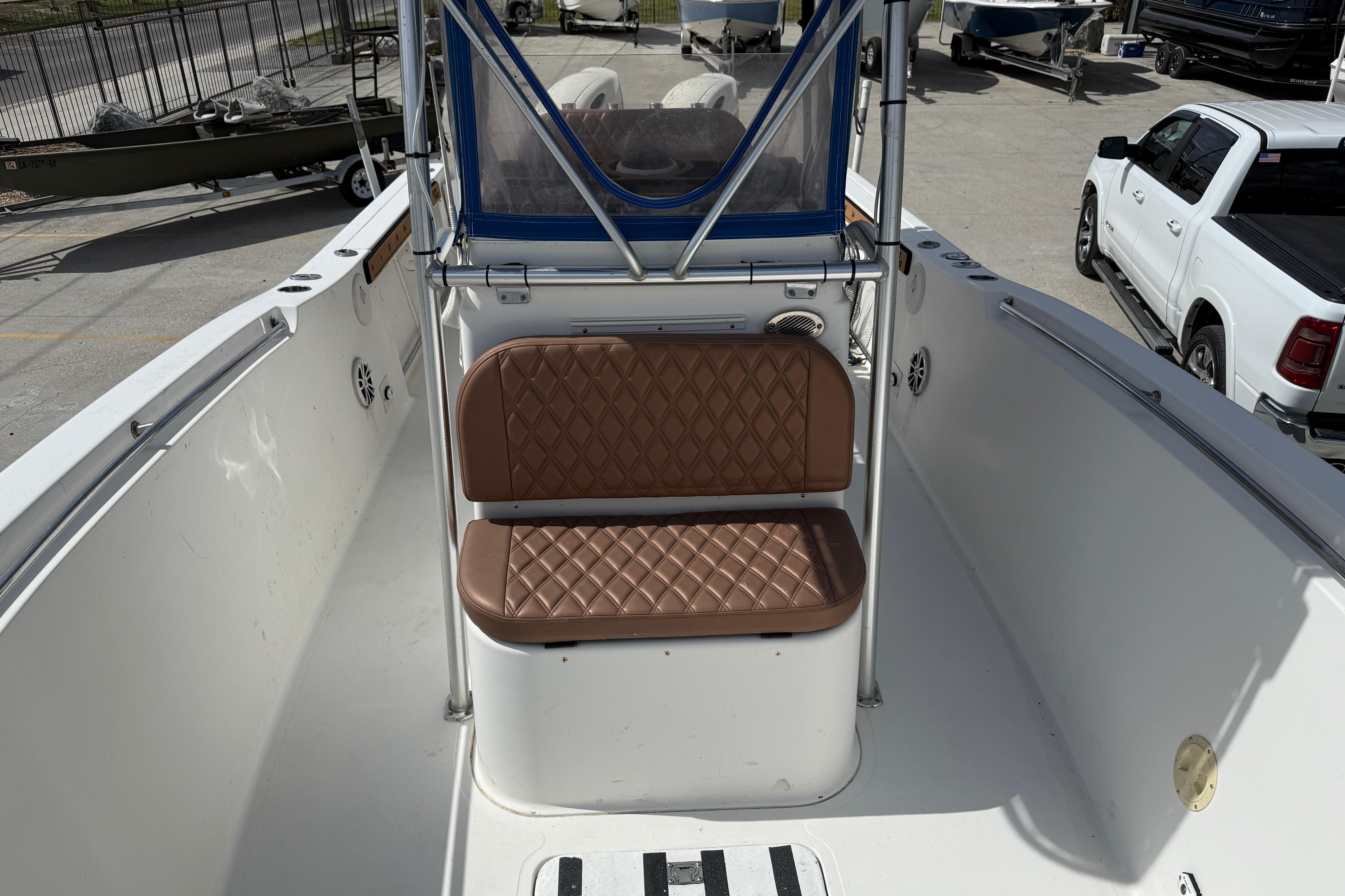 2007 Sea Pro 270 Center Console boat with brown cushioned seating and blue canopy.