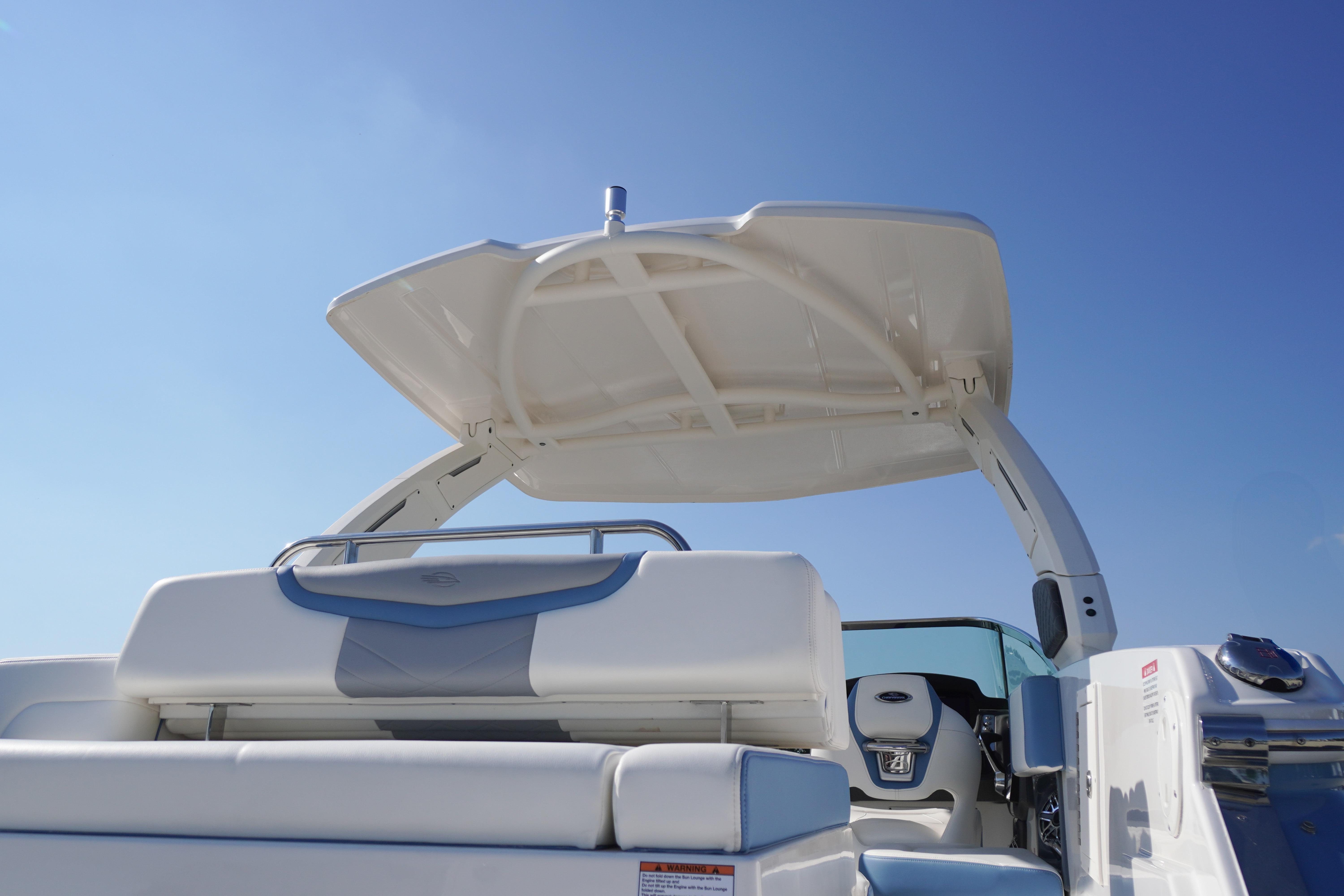 2026 Chaparral 270 OSX boat with sleek seating and canopy under clear blue sky.