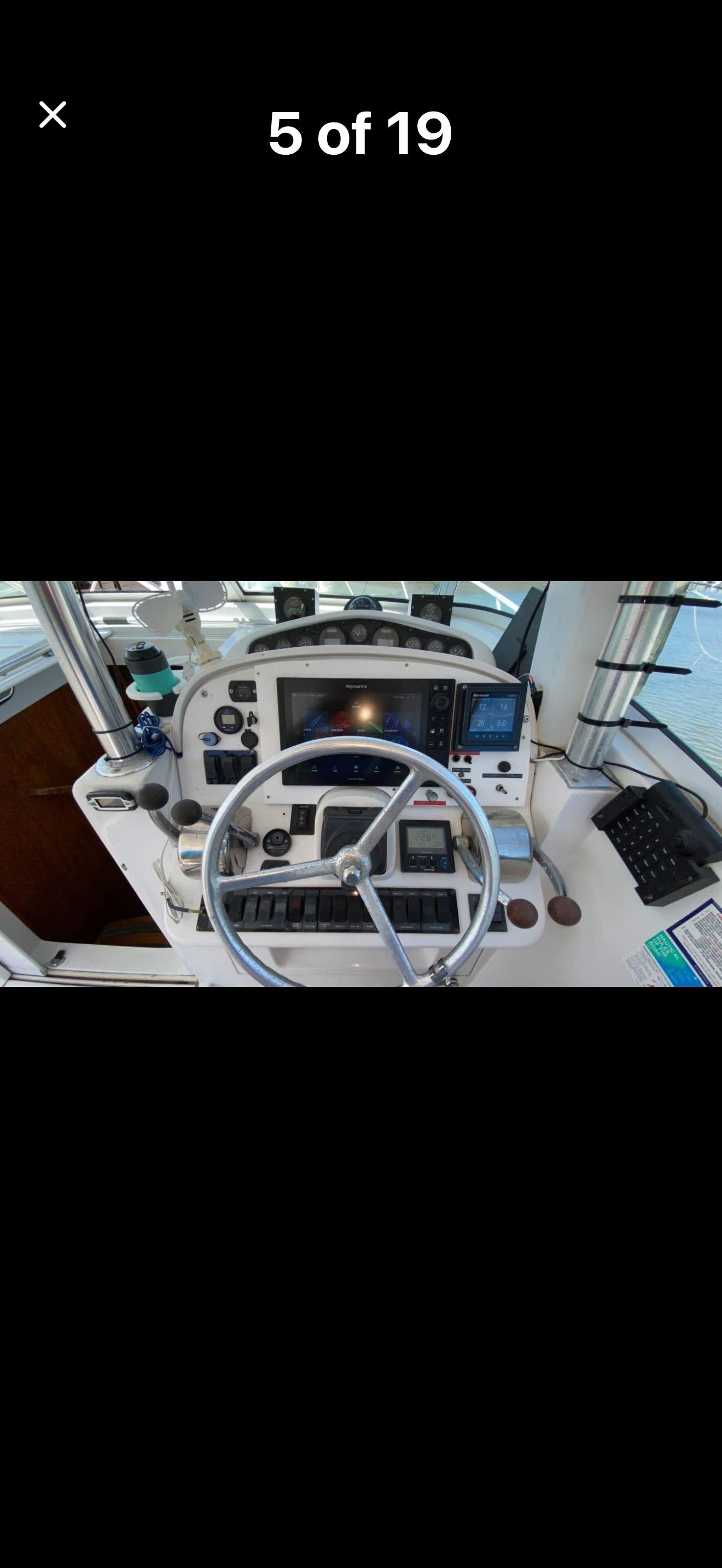 The image shows the helm of a 1999 Luhrs Sx36 with a steering wheel and instruments.