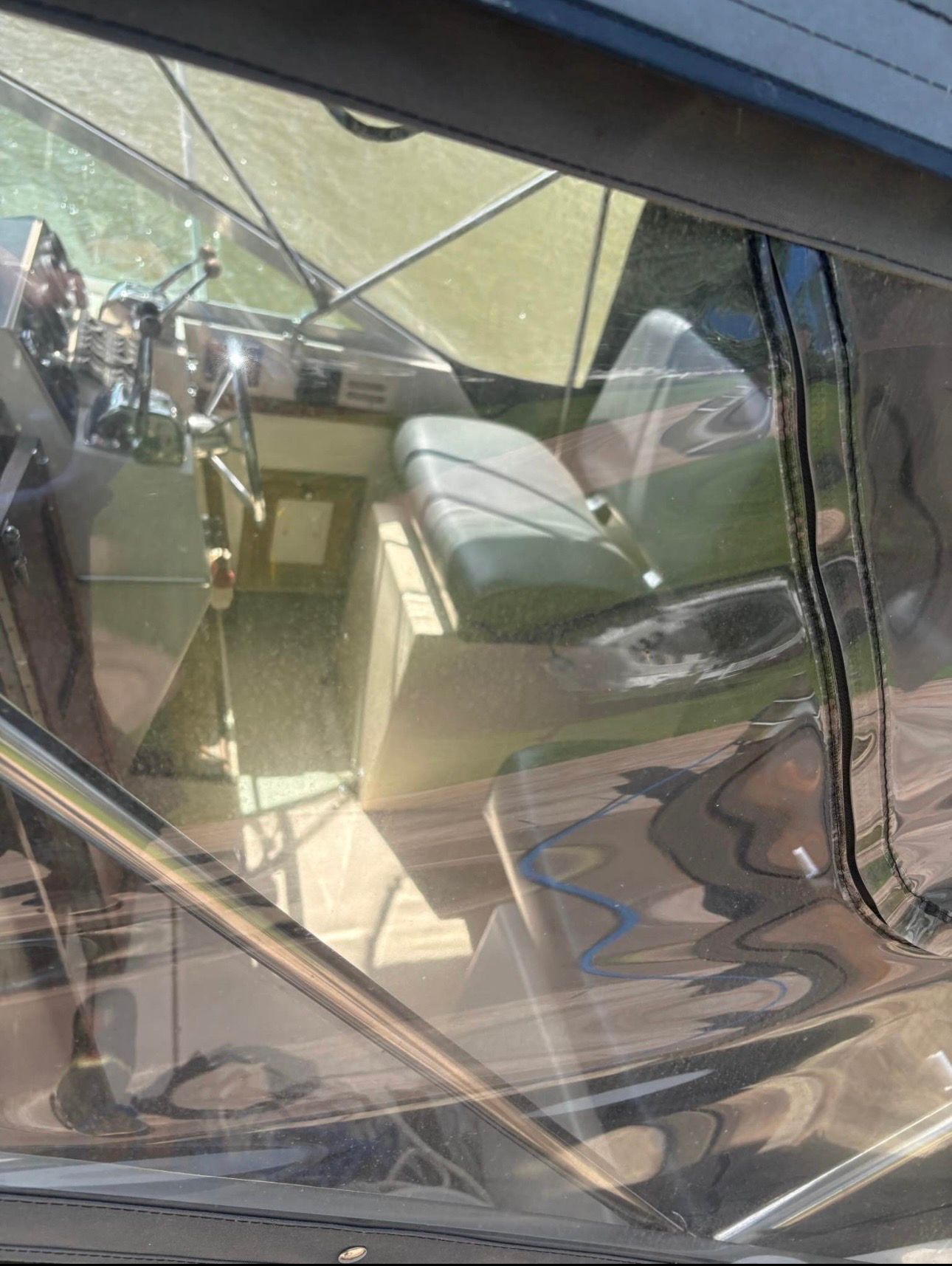 Interior view of a boat with a bench seat and helm station.