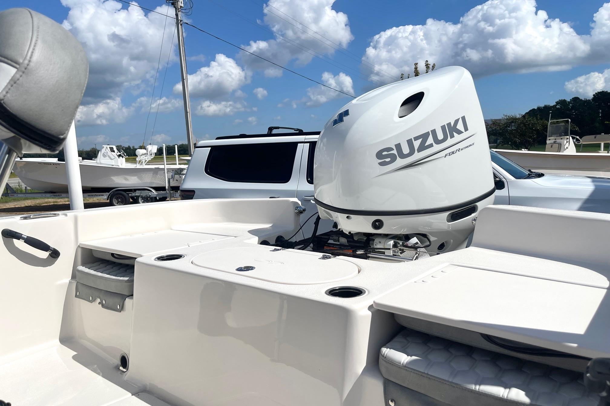 2026 Carolina Skiff 19 LS boat with Suzuki outboard motor under a blue sky.