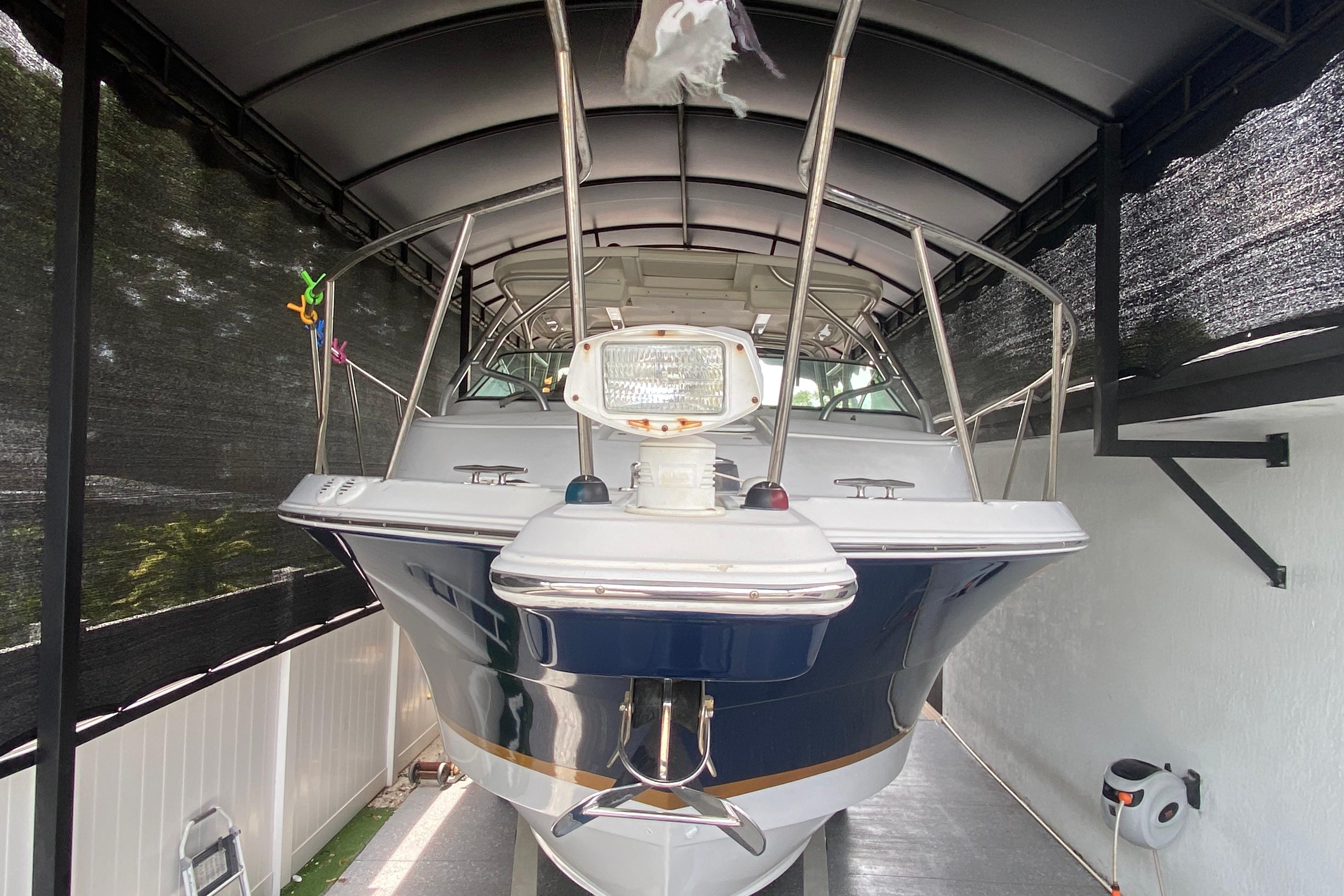 2005 Wellcraft 290 Coastal boat under a covered dock, front view.