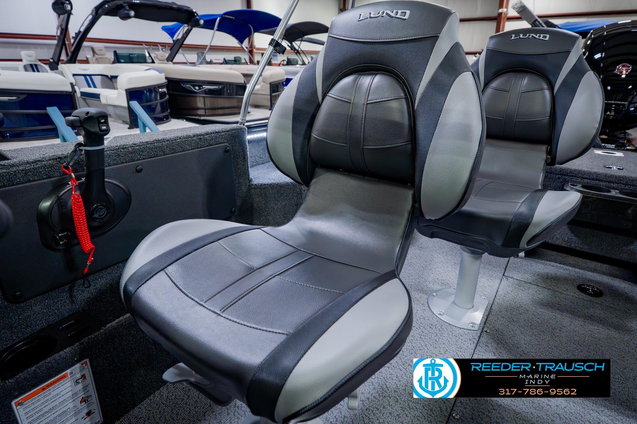 2026 Lund 1875 Impact XS boat seats in showroom, featuring sleek black and gray design.
