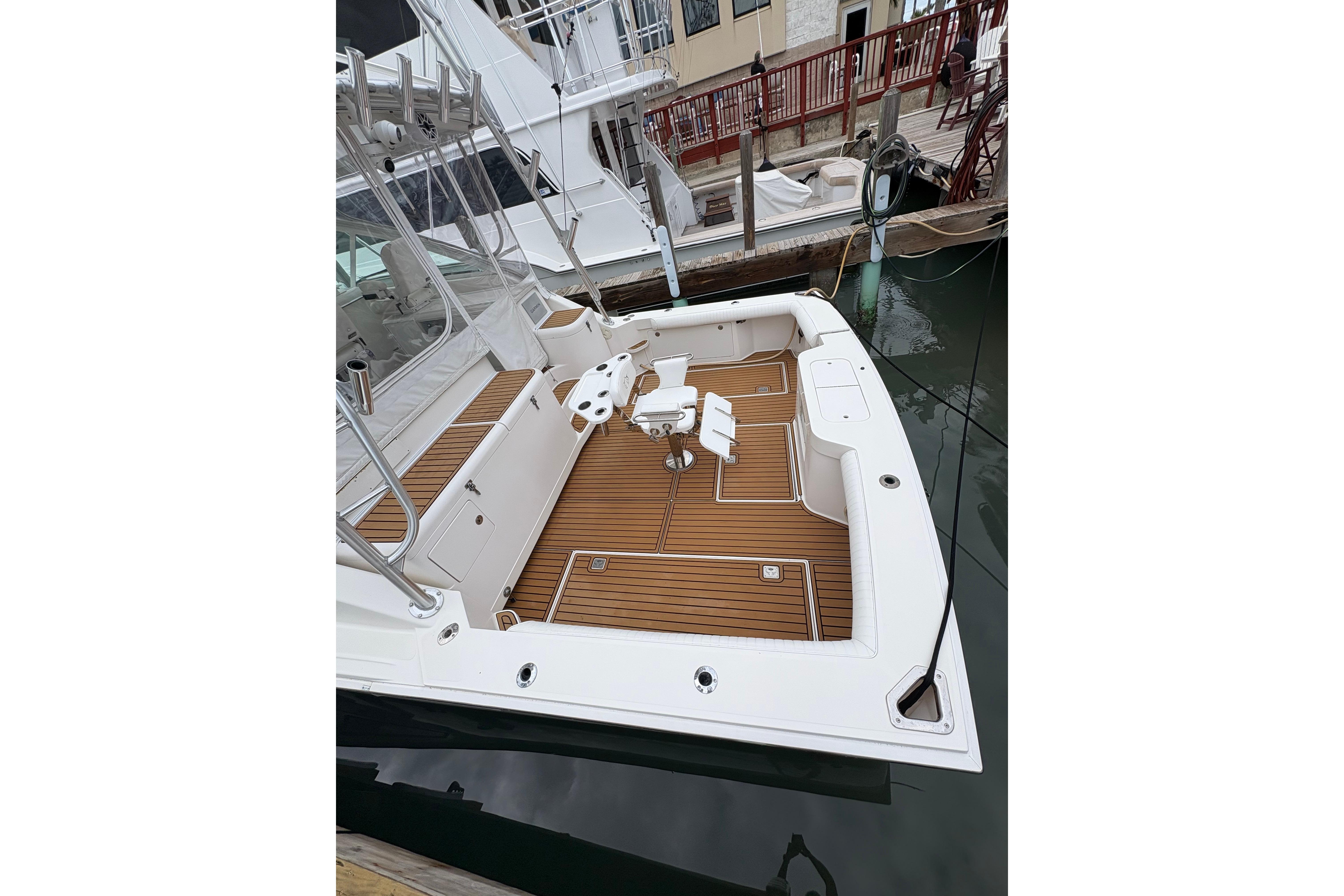 2004 Cabo 40 Hardtop Express boat with teak deck, docked at marina.