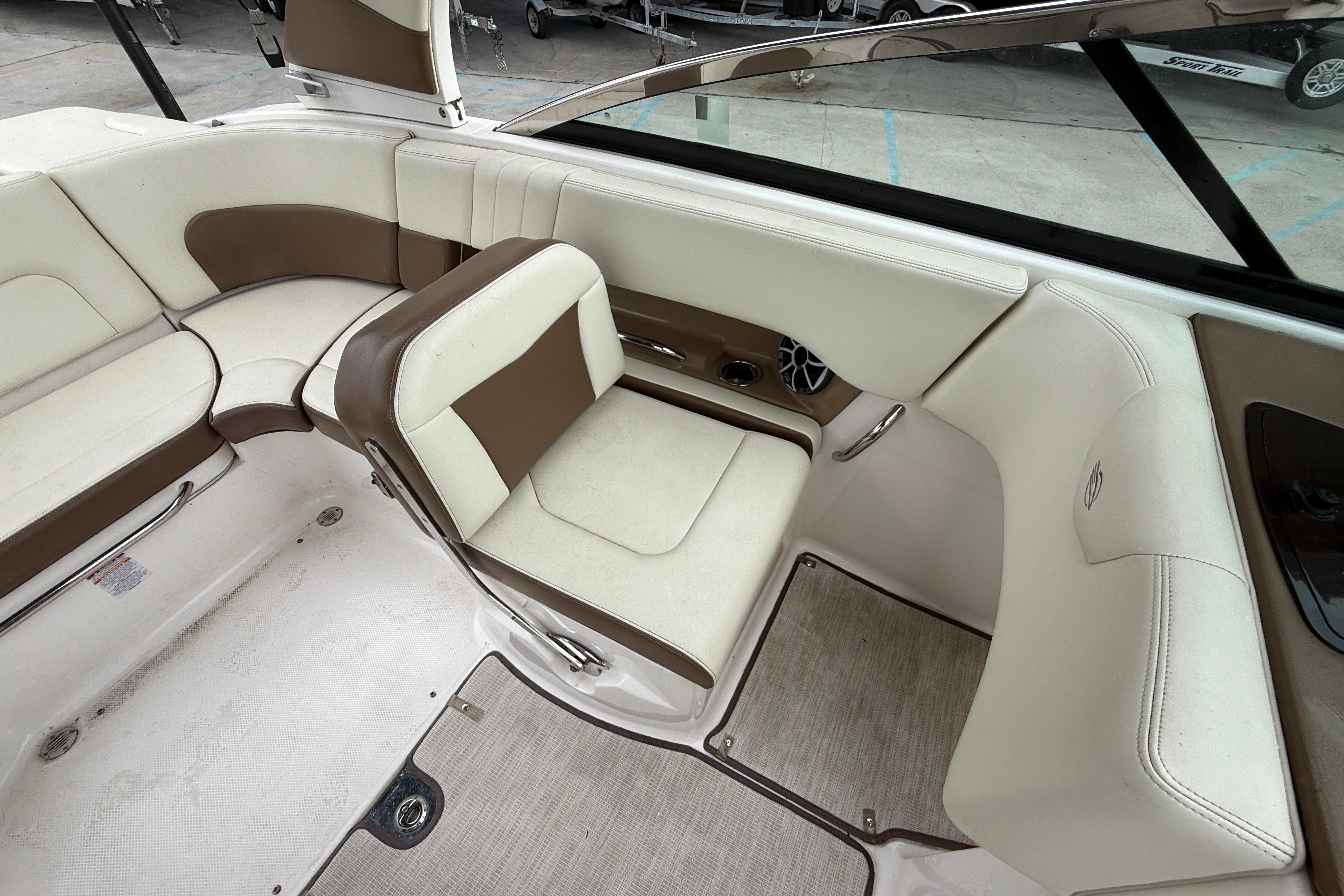 2018 Chaparral 227 SSX Surf boat interior with beige and brown seating.