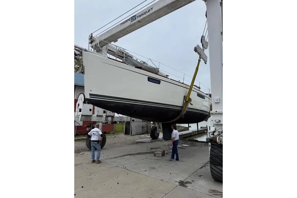 Bavaria Vision 46 sailboat from 2016 being lifted by a crane at a marina.