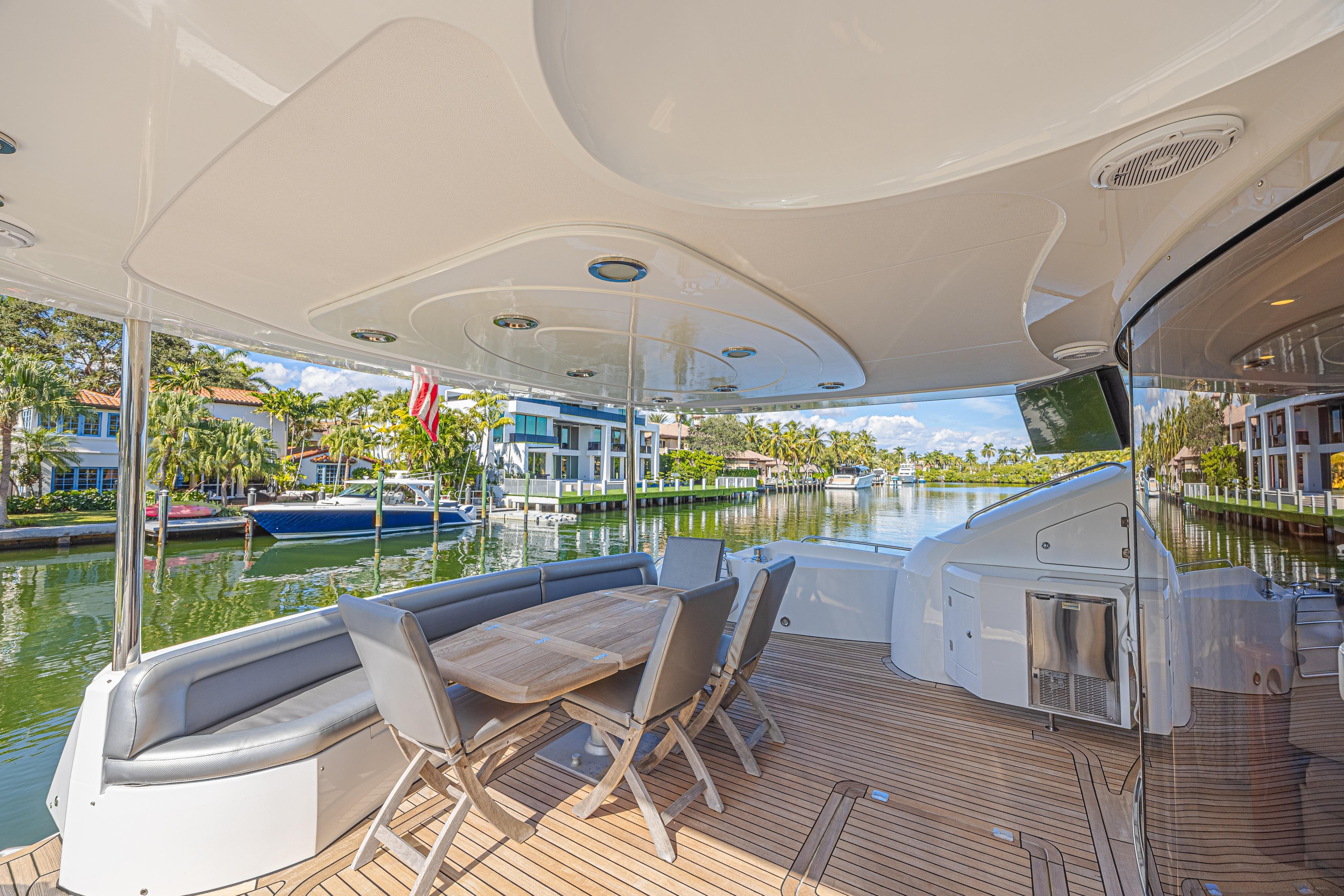 Luxurious 2006 Sunseeker 75 Yacht deck with elegant seating and scenic waterfront view.